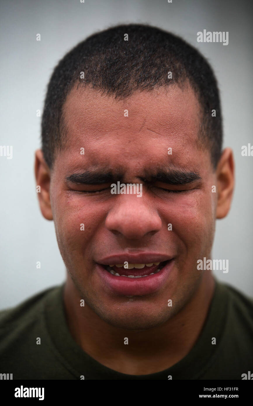 Lance Cpl. Anthony Bello poses for a photo after being sprayed in the face with oleoresin capsicum, or OC spray, and running through a confidence course March 6 on Marine Corps Air Station Futenma, Okinawa, Japan. “It’s like someone lit a torch to my face,” he said. Bello and other Marines temporarily assigned to the security augment force on Marine Corps Installations Pacific-Marine Corps Base Camp Butler, Japan, were introduced to the visceral sensation of the irritant to understand its effects and how to operate if they were exposed while spraying an assailant. Bello is an Everett, Mass., n Stock Photo