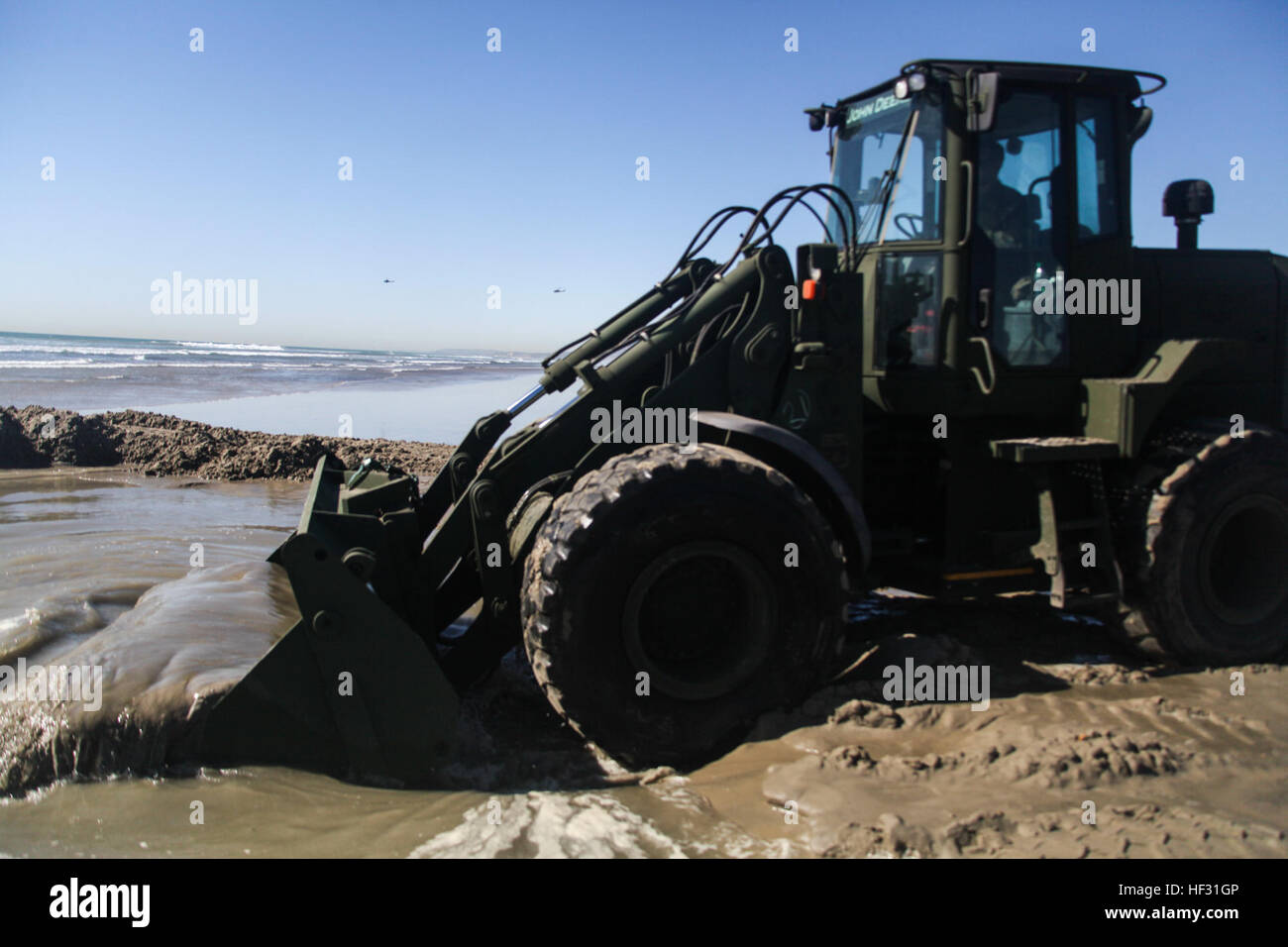 A U.S. Marine with the Combat Logistics Battalion 15, 15th Marine Expeditionary Unit, uses a medium crawler tractor to create a ditch for water aboard Camp Pendleton, Calif., March 6, 2015. The Marines  made drinking water by running ocean water through a tactical water purification system during Amphibious Squadron/Expeditionary Unit Integration Training (PMINT).   (U.S. Marine Corps photo by Cpl. Elize McKelvey/Released) 15th MEU Marines provide drinking water from ocean 150307-M-JT438-210 Stock Photo