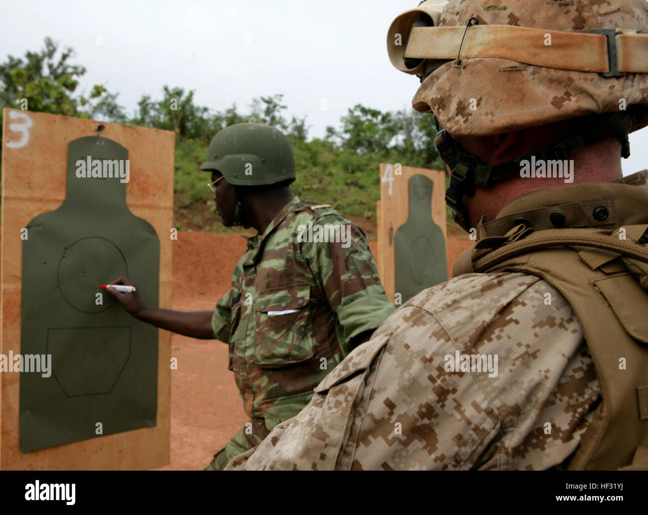 BEMBEREKE, Benin - A Beninese range coach checks targets with a U.S. Marine after exchanging weapons for a live fire exercise here, June 13. Marines, coached by Beninese soldiers, fired AK-56s.  The live fire evolution is part of an Exercise SHARED ACCORD 09 training evolution.  SHARED ACCORD is a scheduled 15-day, bilateral U.S.-Benin training event designed to improve interoperability and mutual understanding of each nation’s tactics, techniques and procedures.  The training will focus on individual and crew served weapons proficiency and small unit training tactics, techniques and procedure Stock Photo