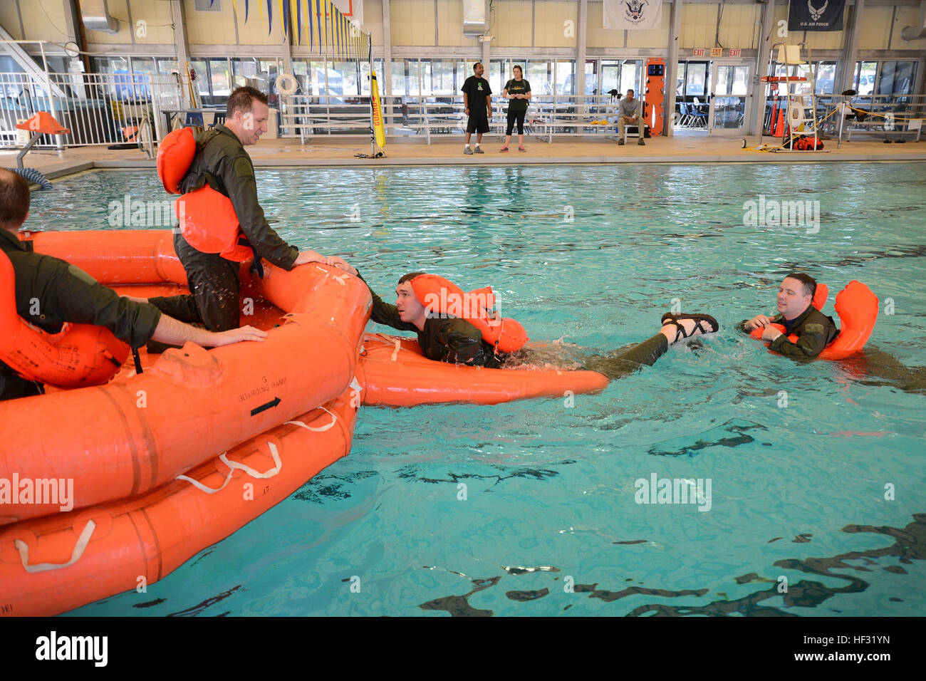 The 108th Wing Airmen climb onto a 20-man life raft in the Water Survival training course March 8, 2015, at the Joint Base McGuire-Dix-Lakehurst, N.J., pool. Aircrew members must receive conintuation training every 36 months. The aircrew flight equipment instructors, from the 108th Operations Support Squadron, teach aircrew members how to use the safety equipment on their aircraft. (U.S. Air National Guard Photo by Airman 1st Class Julia Pyun/Released) Water survival training 150308-Z-VC328-088 Stock Photo
