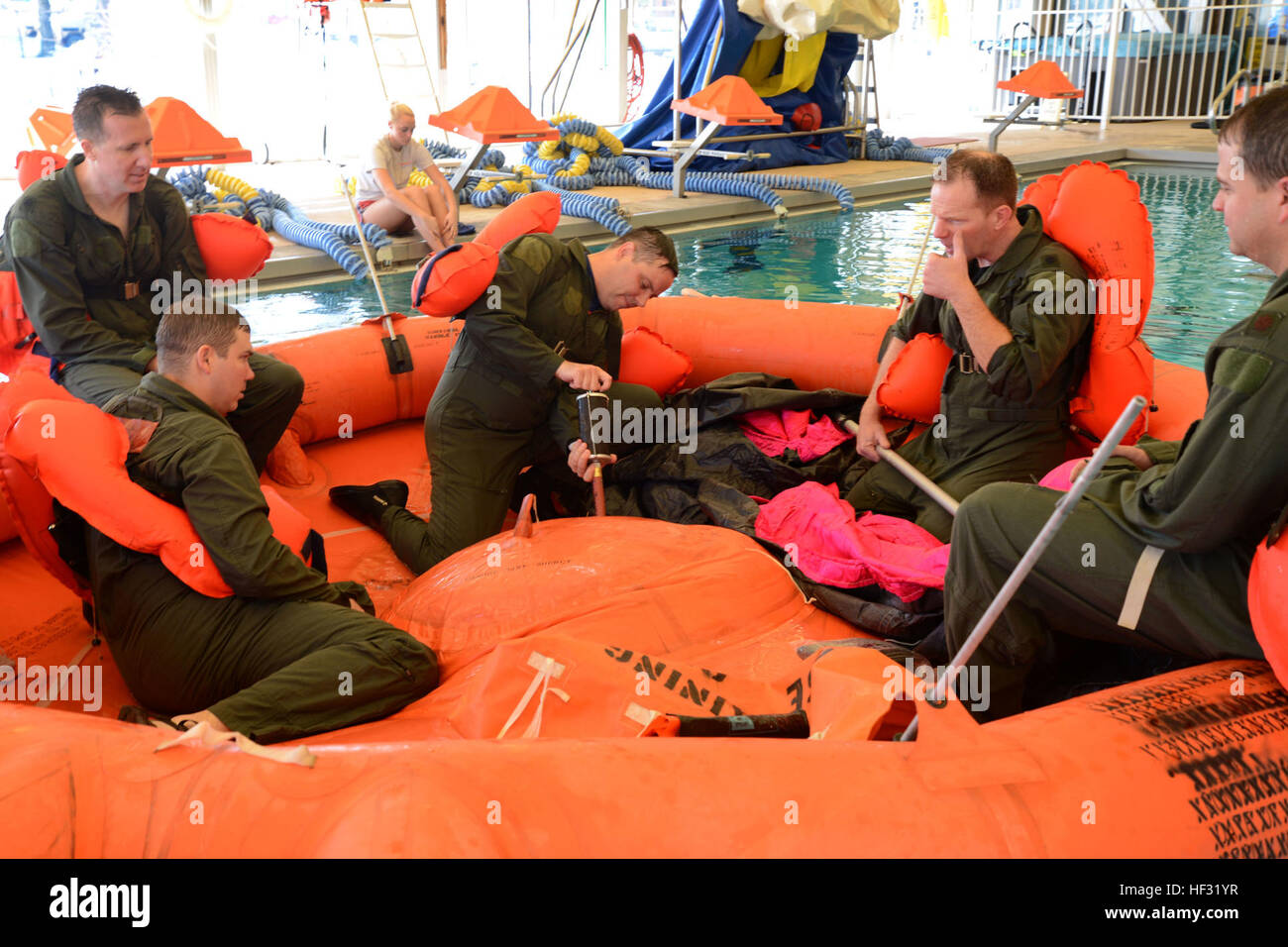 The 108th Wing Airmen pump air into the 20-man life raft in the water survival training course March 8, 2015, at the Joint Base McGuire-Dix-Lakehurst, N.J., pool. Aircrew members must receive continuation training every 36 months. The aircrew flight equipment instructors, from the 108th Operations Support Squadron, teach aircrew members how to use the safety equipment on their aircraft. (U.S. Air National Guard Photo by Airman 1st Class Julia Pyun/Released) Water survival training 150308-Z-VC328-125 Stock Photo
