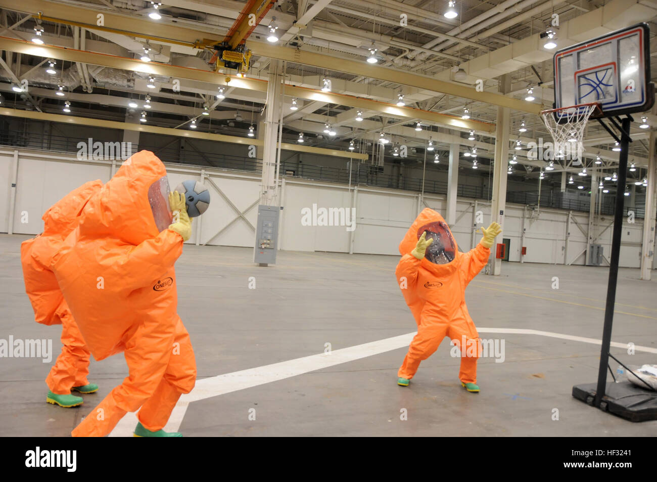 Tech. Sgt. Jeremiah Wirth, 125th Fighter Wing emergency manager, Staff Sgt. Micah Jarrett, 137th Air Refueling Wing EM, and Senior Airman Melissa Isidro, 108th Wing EM, test their dexterity in their hazardous material suits by shooting basketballs during the Level A olympics at the Guardian Centers of Georgia, Perry, Ga., during the Global Dragon deployment for training March 9, 2015. The level A olympics are used to familiarize Airmen in the use of the HAZMAT suits. (U.S. Air National Guard photo by Senior Airman Cody Martin/Released) Global Dragon deployment for training 150309-Z-LK614-108 Stock Photo