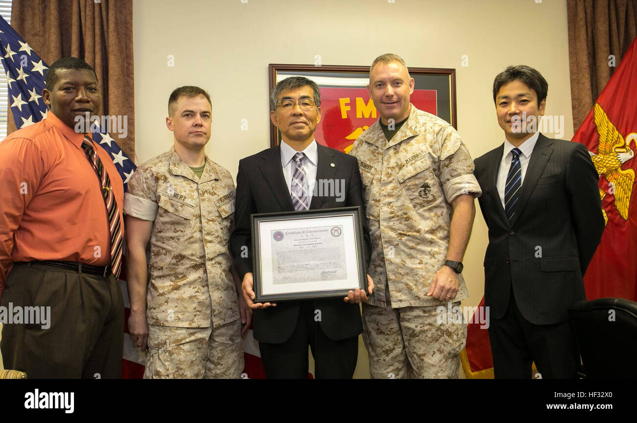Col. Sean M. McBride, center right, and Satoshi, Yamada, retired Ishikawa chief of police, center, met for an award ceremony March 12 at Camp Hansen. The Marine Corps awarded the certificate for actions Yamada performed as chief of police. Yamada is retiring as the police chief after two years. Yamada worked with the III Marine Expeditionary Force by helping with disaster relief, anti-terrorism and evacuation drills, the drunken driving campaign and spoke at the welcome aboard seminars for Marines on the Unit Deployment Program. Yamada is from Naha City, Okinawa. McBride is from Butte, Montana Stock Photo