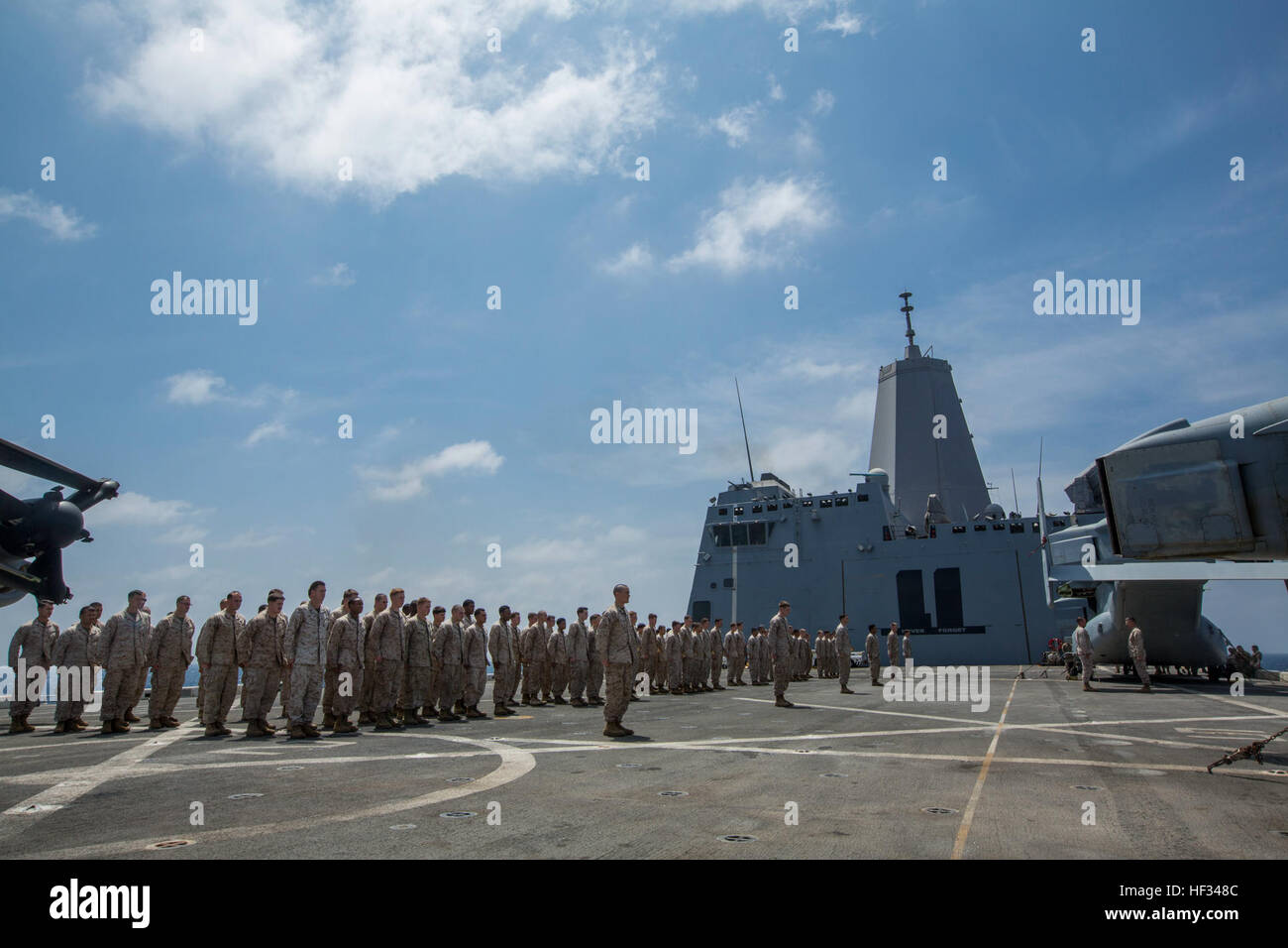 Marines with Combat Logistics Battalion 24, 24th Marine Expeditionary Unit stand in formation for an award ceremony aboard the USS New York (LPD 21), March 19, 2015. The 24th MEU is embarked on the ships of the Iwo Jima Amphibious Ready Group and deployed to maintain regional security in the U.S. 5th Fleet area of operations. (U.S. Marine Corps photo by Cpl. Todd F. Michalek) Marine Awarded Navy Commendation Medal 150319-M-YH418-001 Stock Photo