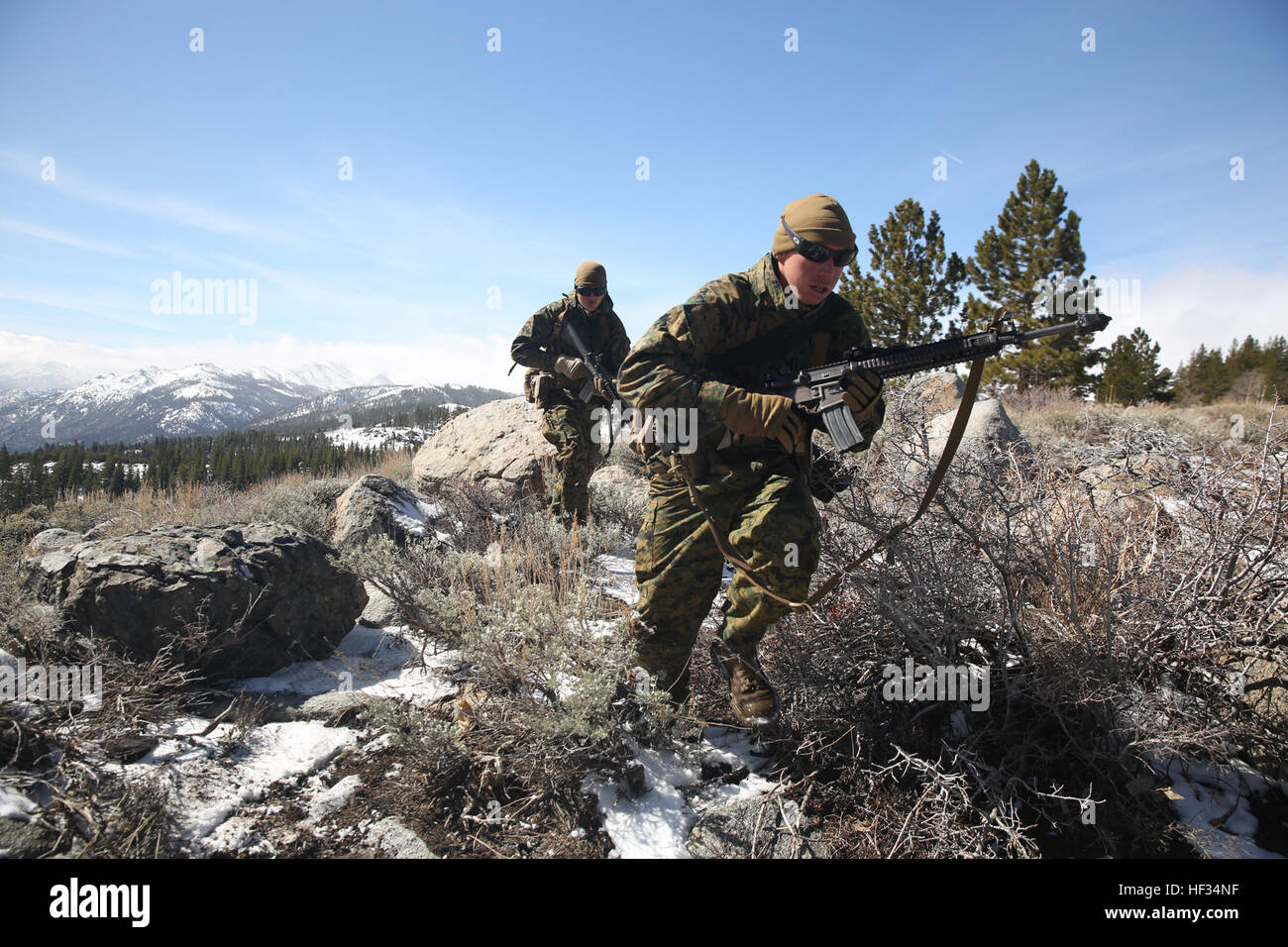 Lance Cpl. Taylor Trion, native of Tulsa, Okla., and Pfc. Joseph Tweedy, native of San Diego, assaultmen with 1st Battalion, 3rd Marine Regiment, sprint to cover during Mountain Training Exercise 2-15 at the Marine Corps Mountain Warfare Training Center, March 23, 2015. (Official Marine Corps photo by Cpl. Charles Santamaria/Released) 'Lava Dogs' prepare for 'every clime and place' 150323-M-YE994-043 Stock Photo