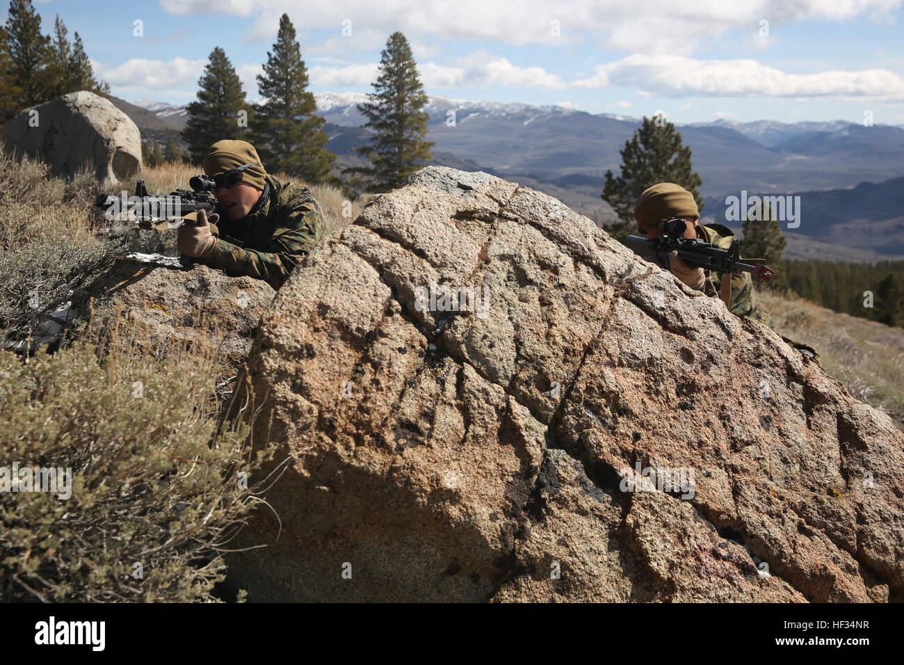 Lance Cpl. Taylor Trion, native of Tulsa, Okla., and Pfc. Joseph Tweedy, native of San Diego, assaultmen with 1st Battalion, 3rd Marine Regiment, set up security behind a boulder during Mountain Training Exercise 2-15 at the Marine Corps Mountain Warfare Training Center,  March 23, 2015. (Official Marine Corps photo by Cpl. Charles Santamaria/Released) 'Lava Dogs' prepare for 'every clime and place' 150323-M-YE994-553 Stock Photo