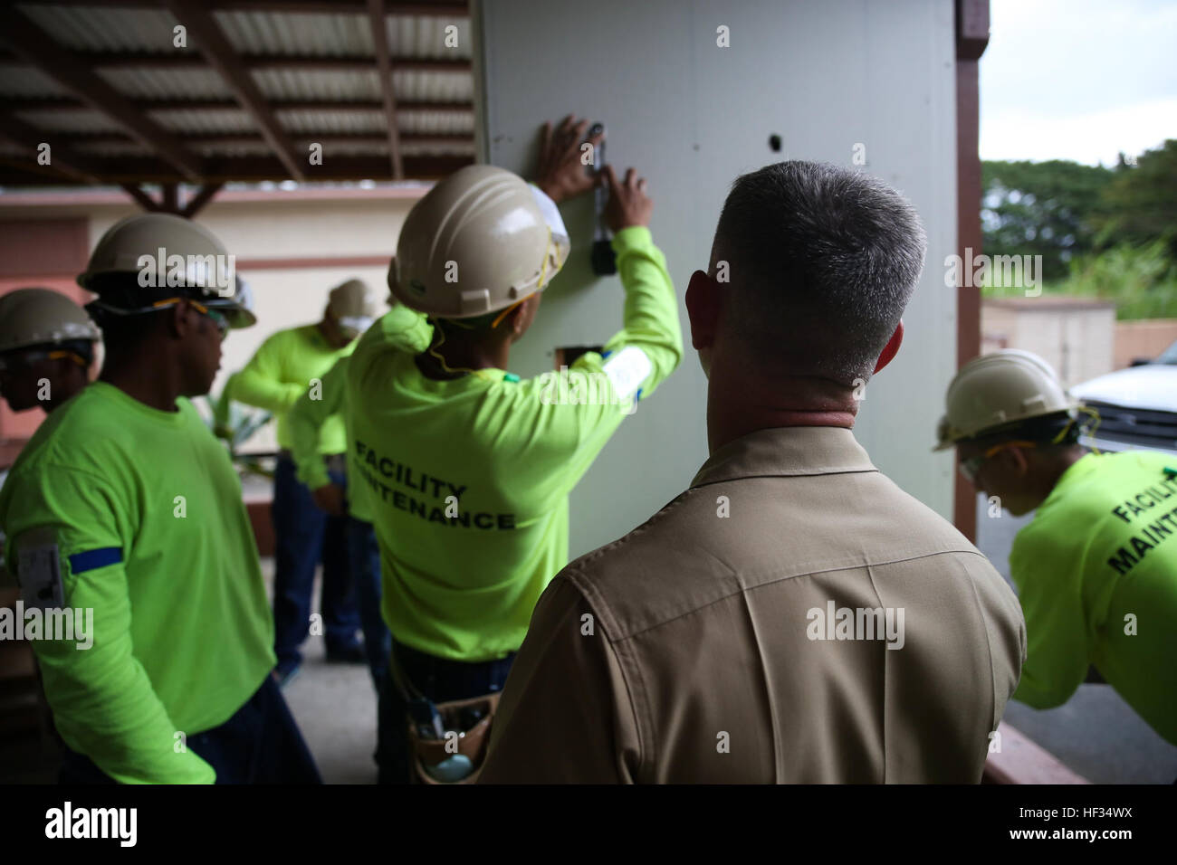 Representatives from Marine Corps Base Hawaii watch as students in the Job Corps program practice filling and covering holes in drywall March 24, 2015, aboard the Job Corps Center in Waimanalo. The center in Waimanalo offers nine career field opportunities for their students, ranging from culinary arts to facilities maintenance or nursing assistance, and all of the programs are aligned to national training and certification standards. (U.S. Marine Corps photo by Lance Cpl. Harley Thomas/released) Hawaii Job Corps pushes students toward summit 150324-M-SB674-179 Stock Photo