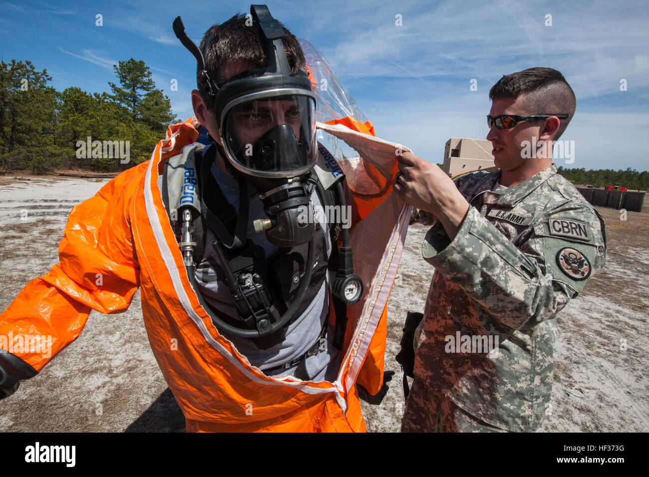 Staff Sgt. Chris M. Maute, right, assists Sgt. 1st Class Steve B. Kovacs, both with the 21st Weapons of Mass Destruction Civil Support Team (WMD CST), New Jersey National Guard, into his Level A Protective Suit during a full-scale Homeland Response Force exercise involving units from the New Jersey and New York Army and Air National Guard at Joint Base McGuire-Dix-Lakehurst, N.J., April 16, 2015. The Chemical, Biological, Radiological and Nuclear (CBRN) portion of the exercise was performed by National Guard Soldiers and Airmen from New Jersey’s 21st Weapons of Mass Destruction Civil Support T Stock Photo