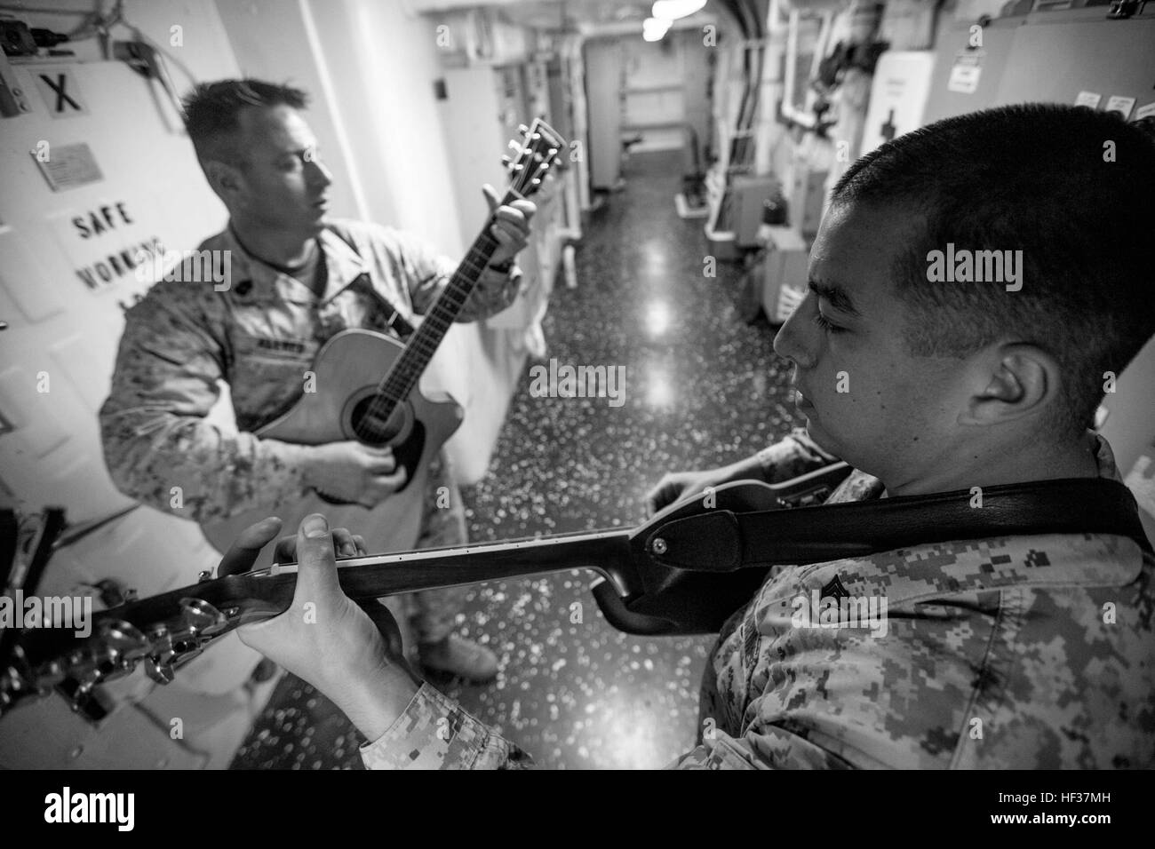Sergeant Nicolas Rublein, right, a cyber network operator with Battalion Landing Team 3rd Battalion, 6th Marine Regiment, 24th Marine Expeditionary Unit, and 1stSgt. Allen Allred, Company 1stSgt, Light Armored Reconnaissance, BLT 3/6, 24th MEU, play music in a passageway aboard the amphibious transport dock ship USS New York (LPD 21), April 21, 2015. The 24th MEU is currently embarked on the ships of the Iwo Jima Amphibious Ready Group and deployed to maintain regional security in the U.S. 5th Fleet Area of operations. (U.S. Marine Corps photo by Cpl. Todd F. Michalek/Released) An unlikely Mar Stock Photo