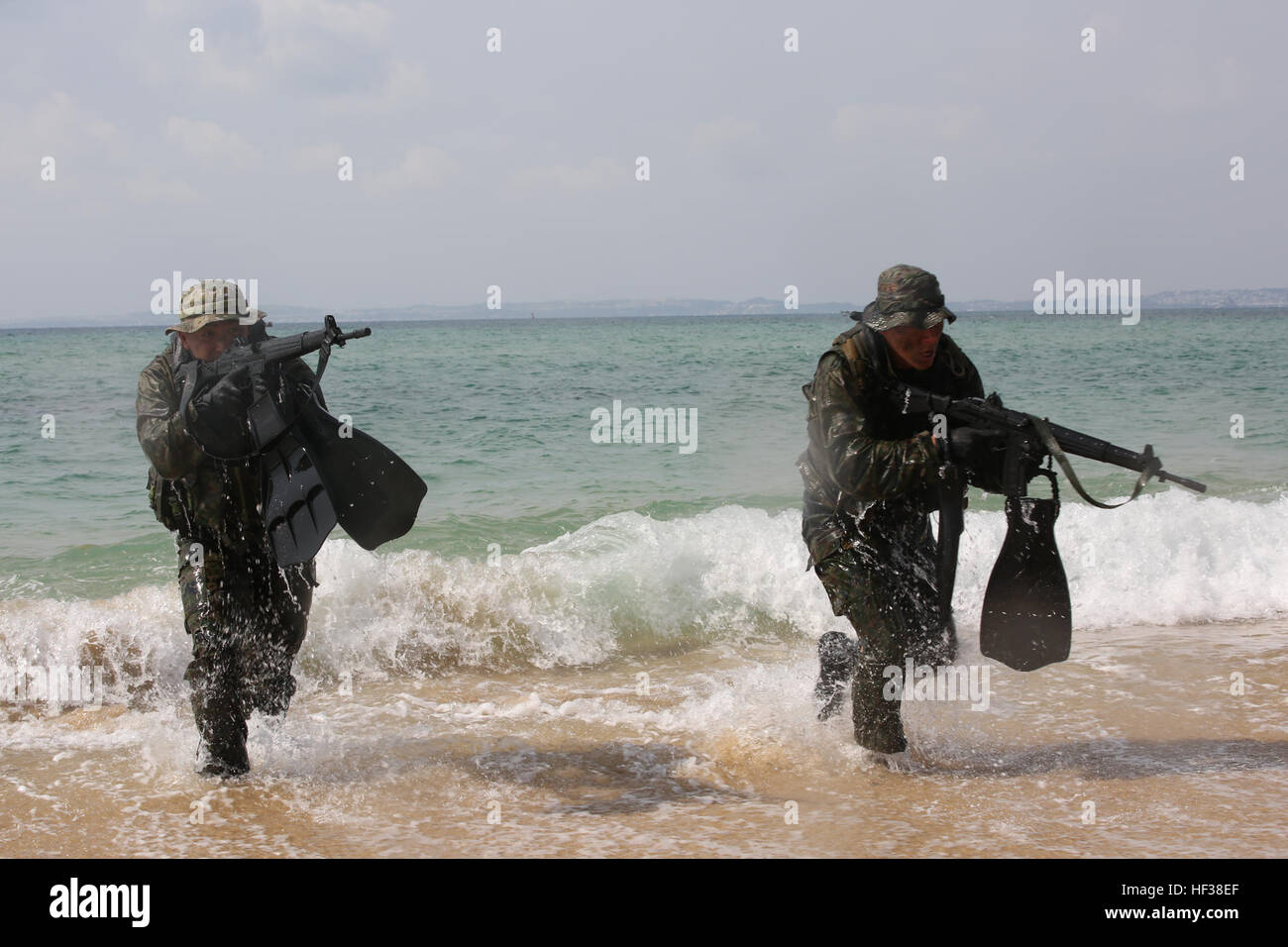 Japanese Ground Self-Defense Force scout swimmers emerge out of the ocean and run to the beach during the Japanese Observer Exchange Program April 27, 2015 at Kin Blue. JOEP is a III Marine Expeditionary Force, 31st Marine Expeditionary Unit and JGSDF coordinated program designed to increase regional security, maintain unit readiness and enhance overall cooperation. This is the fourth iteration of JOEP for the 31st MEU after the initial partnership in September 2012. (U.S. Marine Corps photo by Cpl. Ryan C. Mains/Released) JGSDF comes together with U.S. Marines 150427-M-WM612-361 Stock Photo