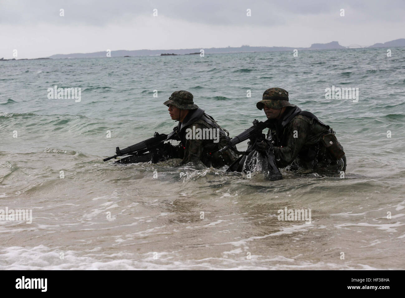 Japanese Ground Self-Defense Force scout swimmers emerge out of the water and sight in on their rifles during the Japanese Observer Exchange Program April 28, 2015 at Kin Blue. JOEP is a III Marine Expeditionary Force, 31st Marine Expeditionary Unit and JGSDF coordinated program designed to increase regional security, maintain unit readiness and enhance overall cooperation. This is the fourth iteration of JOEP for the 31st MEU after the initial partnership in September 2012. (U.S. Marine Corps photo by Cpl. Ryan C. Mains/Released) JGSDF comes together with U.S. Marines 150428-M-WM612-525 Stock Photo