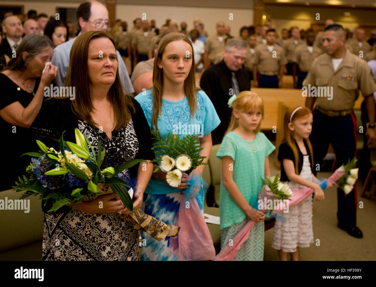 Monica Jones and her daughters Isabella, Brianna, and Makayla, the immediate family of Gunnery Sgt. Eugene E. Jones, U.S. Marine Corps (deceased) await the beginning of the Memorial Service being held for GySgt Jones at the base Chapel aboard Marine Corps Base Hawaii, Kaneohe Bay, May 4, 2015. GySgt. Jones passed away on Wednesday, April 29. 2015 at the age of 41. (U.S. Marine Corps photo by Cpl. Ricky S. Gomez/Released) Gunnery Sergeant Eugene E. Jones Memorial Service 140417-M-ZQ619-010 Stock Photo