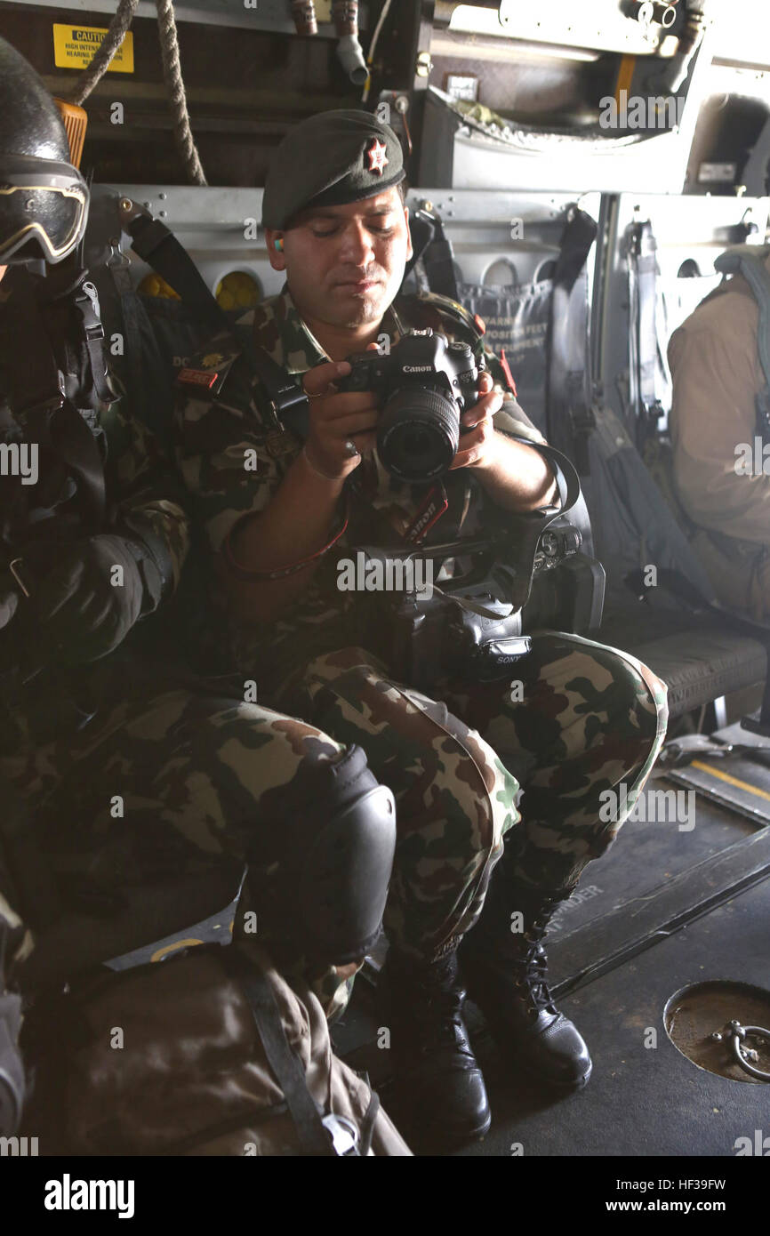 A Nepalese army photographer checks his images during an MV-22 Osprey flight May 5, 2015. The Nepalese Government requested the U.S. Government’s assistance after a 7.8 magnitude earthquake struck the country, April 25, 2015. U.S. Marines from III Marine Expeditionary Force came together with other U.S. services to form Joint Task Force 505. JTF-505 will work in conjunction with USAID and the international community to provide unique capabilities to assist Nepal. (U.S. Marine Corps photo by MCIPAC Combat Camera CWO3 Clinton Runyon/Released) U.S. Marine Ospreys transport Nepalese military, surv Stock Photo