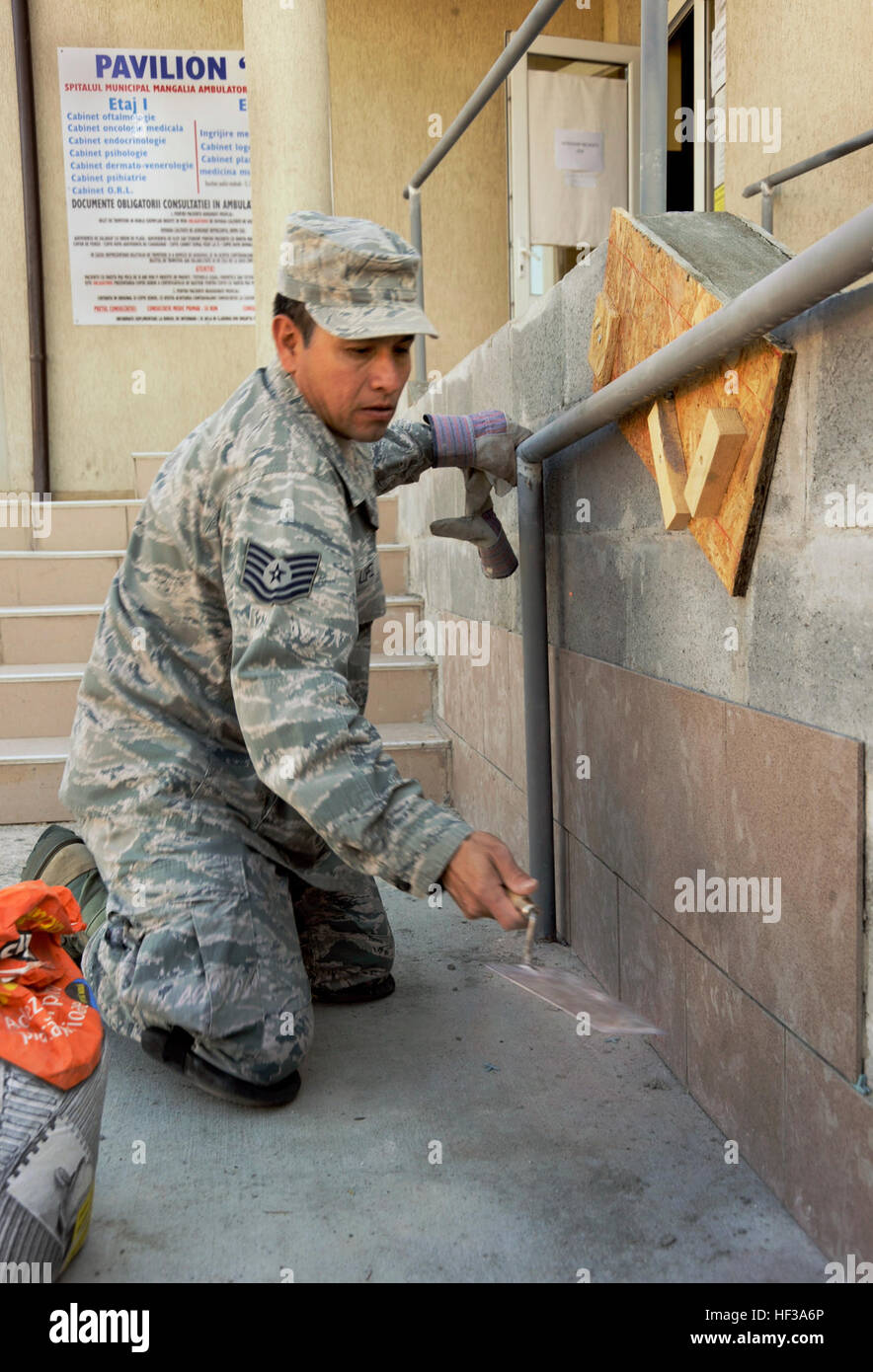 Air National Guardsmen install tiles on a wheelchair ramp at a medical ...