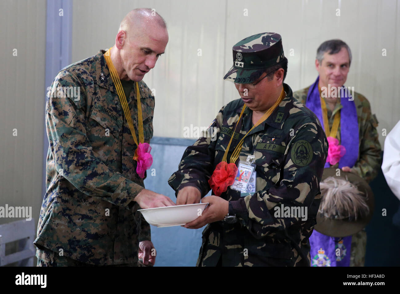 Armed Forces of the Philippines Maj. Gen. Emeraldo C. Magnaye, right, and U.S. Marine Maj. Gen. Richard Simcock prepare to throw rice and coins during a dedication ceremony May 14 in Guinobatan, Albay province, Philippines. The rice and coins represent good luck and fortune in the future. Dedication ceremonies were held around Albay to recognize the completion of the five engineering civic assistance program sites taking place as a part of Exercise Balikatan, including renovations of a school, building of classrooms, and construction of a health center. The exercise is currently in its 30th it Stock Photo