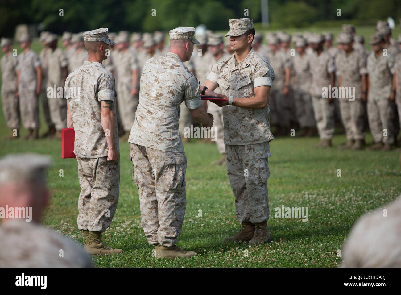 U.S. Marine Corps Lance Cpl. Roman A. Alvarado, right, an entry-level Marine with Alpha Company (Alpha Co.) Infantry Training Battalion, School of Infantry-East receives an award from Capt. Mikelis J. Visgauss, Company Commander, Alpha Co., during the Alpha Co. Graduation Ceremony on Camp Geiger, N.C., May 21, 2015. The Marines of Alpha Co. completed the nine week course as part of their last stage of initial military training and will be sent to units in the operating forces. (U.S. Marine Corps photo by Lance Cpl. Andrew Kuppers, SOI-East Combat Camera/Released) Alpha Company Graduation from  Stock Photo