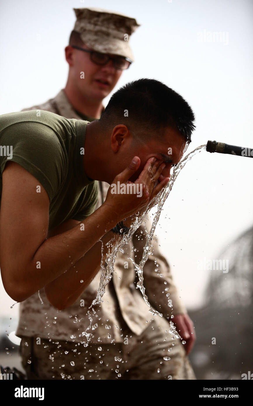 U.S. Marine Lance Cpl. Javier Linares, a rifleman with Company I, 3rd Battalion, 7th Marines, Ground Combat Element, Special Purpose Marine Air Ground Task Force—Crisis Response—Central Command, rinses his face with water after the Oleoresin Capsicum (OC spray) portion of the Nonlethal Weapons Course conducted by the Law Enforcement Detachment for Marines from the Logistics Combat Element and the Ground Combat Element in an undisclosed location within the Central Command Area of Operations, May 26, 2015. Non-lethal weapons training expands the range of capabilities the Marines of SPMAGTF-CR-CC Stock Photo