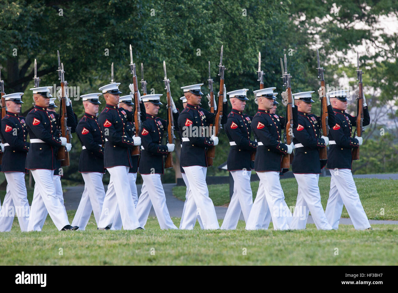 The U.S. Marine Corps Silent Drill Platoon performs during the sunset parade at the Marine Corps War Memorial, Arlington, Va., May 26, 2015. Since September 1956, marching and musical units from Marine Barracks Washington, D.C., have been paying tribute to those who's 'uncommon valor was a common virtue' by presenting sunset parades in the shadow of the 32-foot high figures of the United States Marine Corps War Memorial. (U.S. Marine Corps photo by Lance Cpl. Alejandro Sierras/Released) Sunset Parade 150526-M-GK605-287 Stock Photo