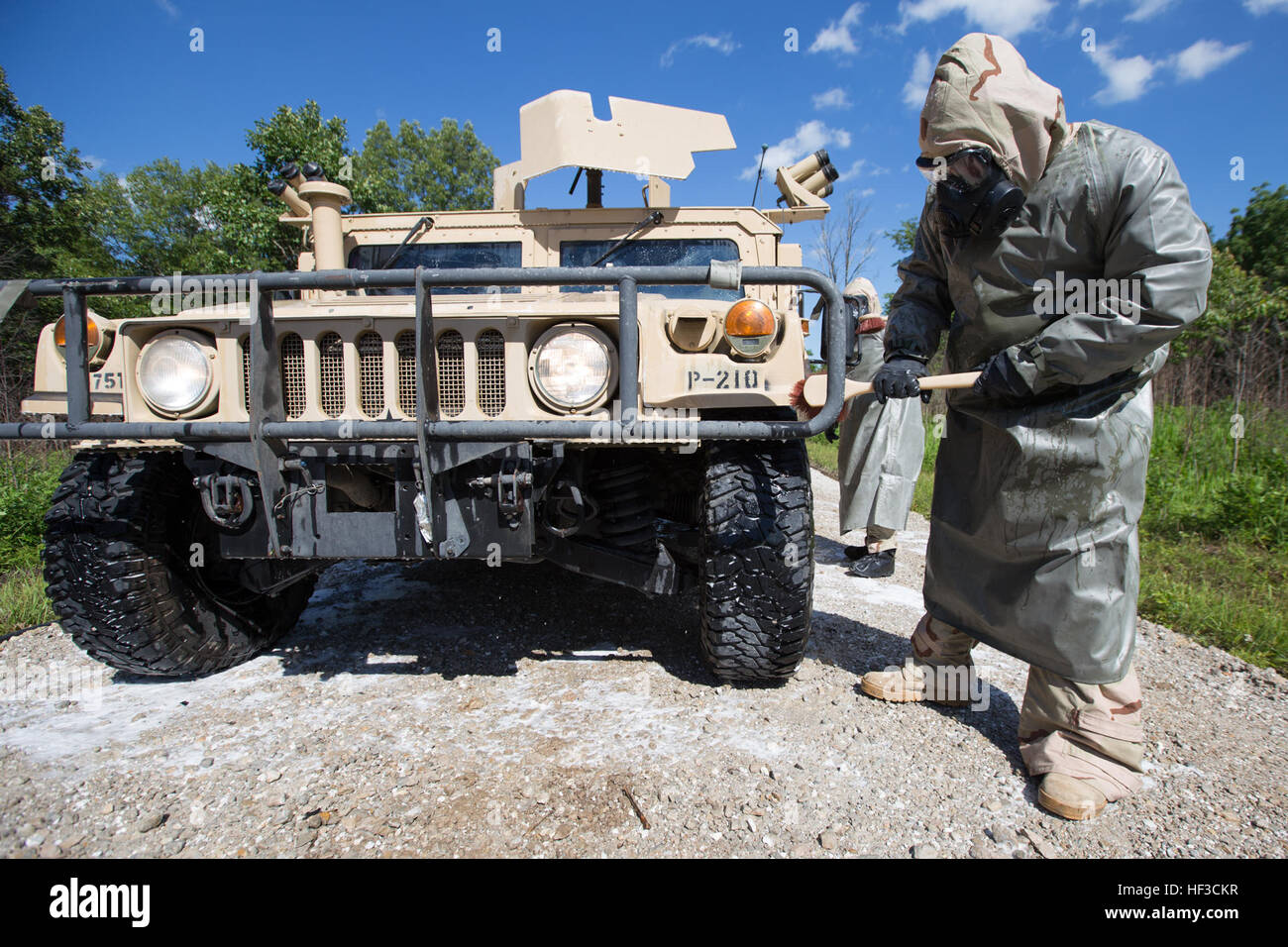 A soldier assigned to the 3175th Chemical Company, 835th Combat Sustainment Support Brigade scrubs a Humvee with cleaning agents during a detailed equipment decontamination during annual training on June 8, 2015 at Fort Leonard Wood, Mo. The soldiers wear MOPP level 4 gear and thoroughly clean and check the vehicles for hazardous chemical contaminants before clearing them for further use. (U.S. Army photo by Pfc. Samantha J. Whitehead) Missouri Guard Chemical Company trains to keep troops, equipment safe 150608-Z-YF431-153 Stock Photo