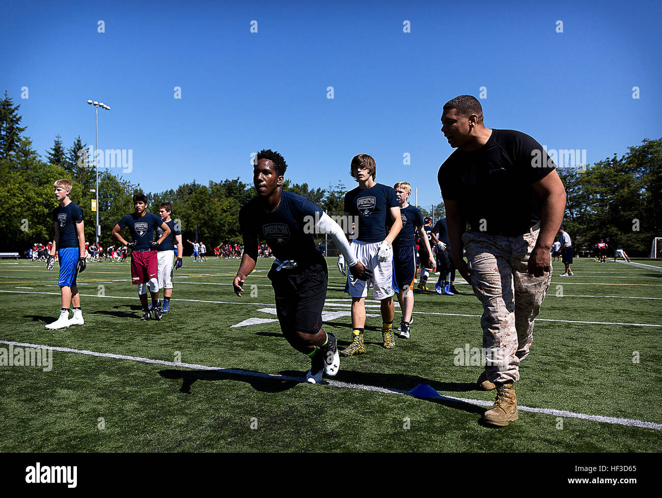Sgt. Bryan Mack, a Marine recruiter in Bellevue, Washington, motivates high school football players during a Semper Fidelis All-American football camp at Hazen High School in Renton, Washington, June 14, 2015. More than 160 players from across Washington State experienced the one-day camp, led by former NFL coaches, local high school coaches and Marines. The camp, which focused on leadership and honor both on and off the field, leads up to the Semper Fidelis All-American Bowl game, which will be played in California in January 2016. (U.S. Marine Corps photo by Sgt. Reece Lodder) Seattle Marine Stock Photo
