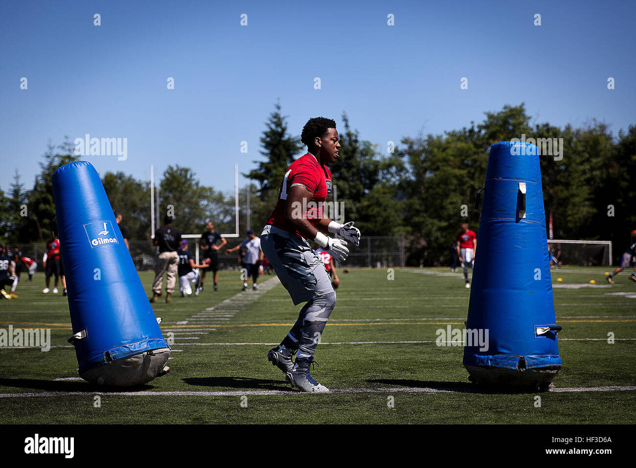 A high school football player runs through a drill during a Semper Fidelis All-American football camp at Hazen High School in Renton, Washington, June 14, 2015. More than 160 players from across Washington State experienced the one-day camp, led by former NFL coaches, local high school coaches and Marines. The camp, which focused on leadership and honor both on and off the field, leads up to the Semper Fidelis All-American Bowl game, which will be played in California in January 2016. (U.S. Marine Corps photo by Sgt. Reece Lodder) Seattle Marines, NFL coaches host football camp in Renton 15061 Stock Photo