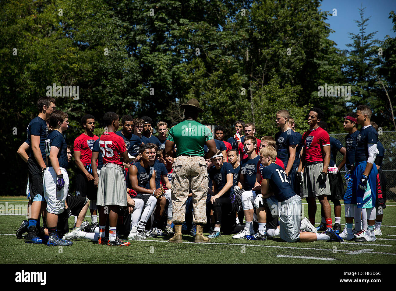 Sgt. Anthony Williams, a drill instructor assigned to Marine Corps Recruit Depot San Diego, speaks to high school football players about the importance of communication during a Semper Fidelis All-American football camp at Hazen High School in Renton, Washington, June 14, 2015. More than 160 players from across Washington State experienced the one-day camp, led by former NFL coaches, local high school coaches and Marines. The camp, which focused on leadership and honor both on and off the field, leads up to the Semper Fidelis All-American Bowl game, which will be played in California in Januar Stock Photo
