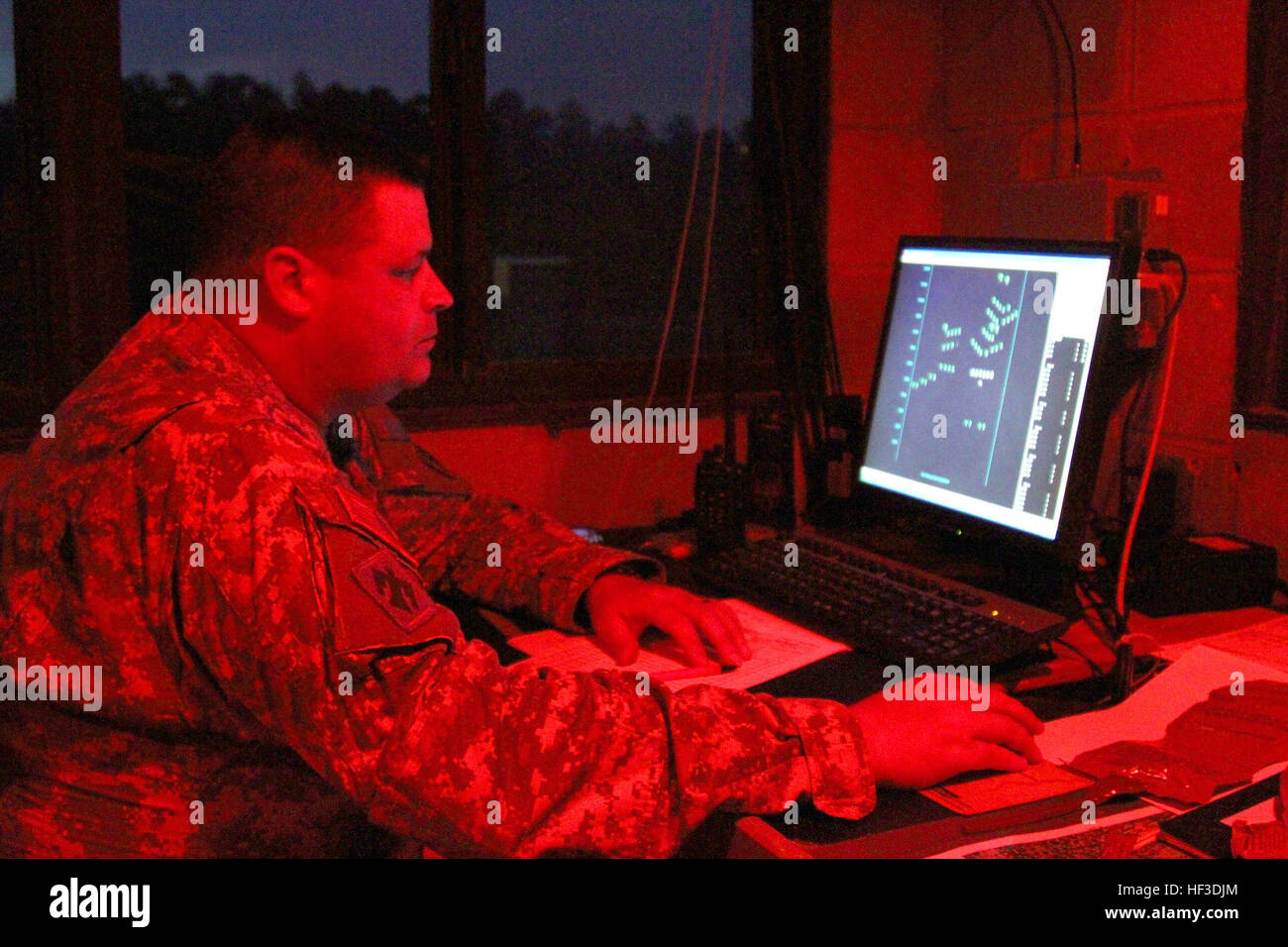 South Carolina National Guard Soldier Capt. Plowden Dixon, 1-118th Infantry Battalion training officer, watches the computer screen in the range tower as Soldiers on the range conduct night exercises June 19, 2015, during their annual training at Fort Stewart, Ga. The screen displays targets the Soldiers must engage which helps keep track of hits. The battalion spent nearly two weeks conducting training in a variety of squad and company level events as part of their annual training. This training helps them prepare for both peacetime situations and when they are called upon to protect the nati Stock Photo