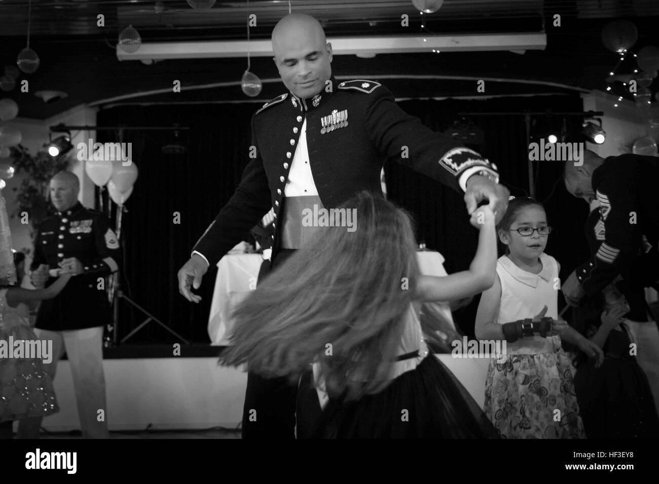 Lt. Col. Quintin D. Jones, commanding officer 1st Battalion, 3rd Marine Regiment, spins his daughter during the Father Daughter Dance hosted by 1st Battalion, 3rd Marines and the Armed Services YMCA at the Officer's Club, June 27, 2015. The event stressed the importance of a father-daughter relationship and gave them an opportunity to spend quality time together. (U.S. Marine Corps photo by Cpl. Brittney Vito/Released) Daddies, Daughters Dance Night Away 150627-M-TM809-001 Stock Photo