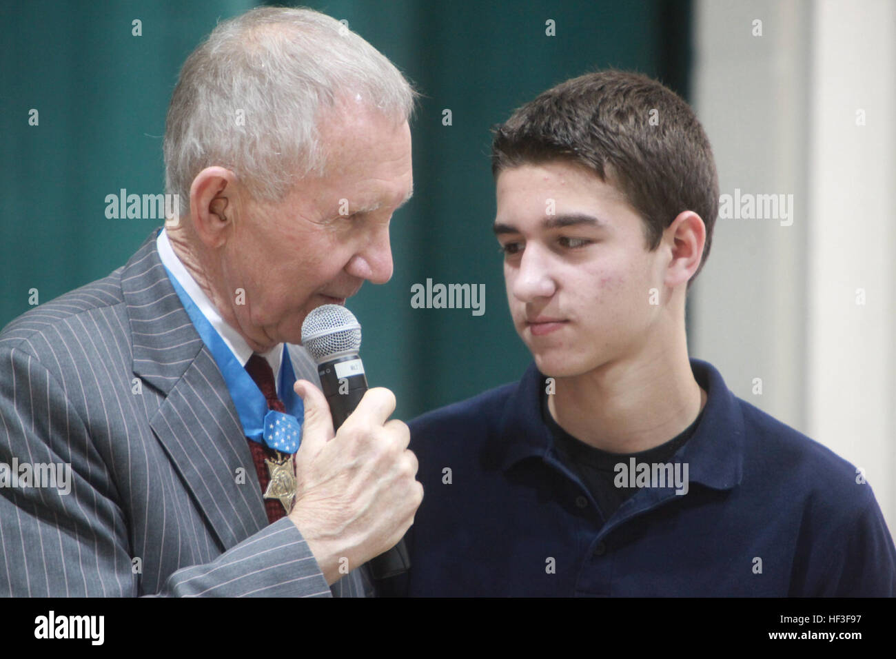 Maj. Gen. James Livingston, retired Marine Corps Medal of Honor recipient, speaks with a middle school student at Bolden Elementary, March 12. Livingston answered questions form why did he decide to become a Marine to his childhood. From one awardee to another DVIDS379167 Stock Photo