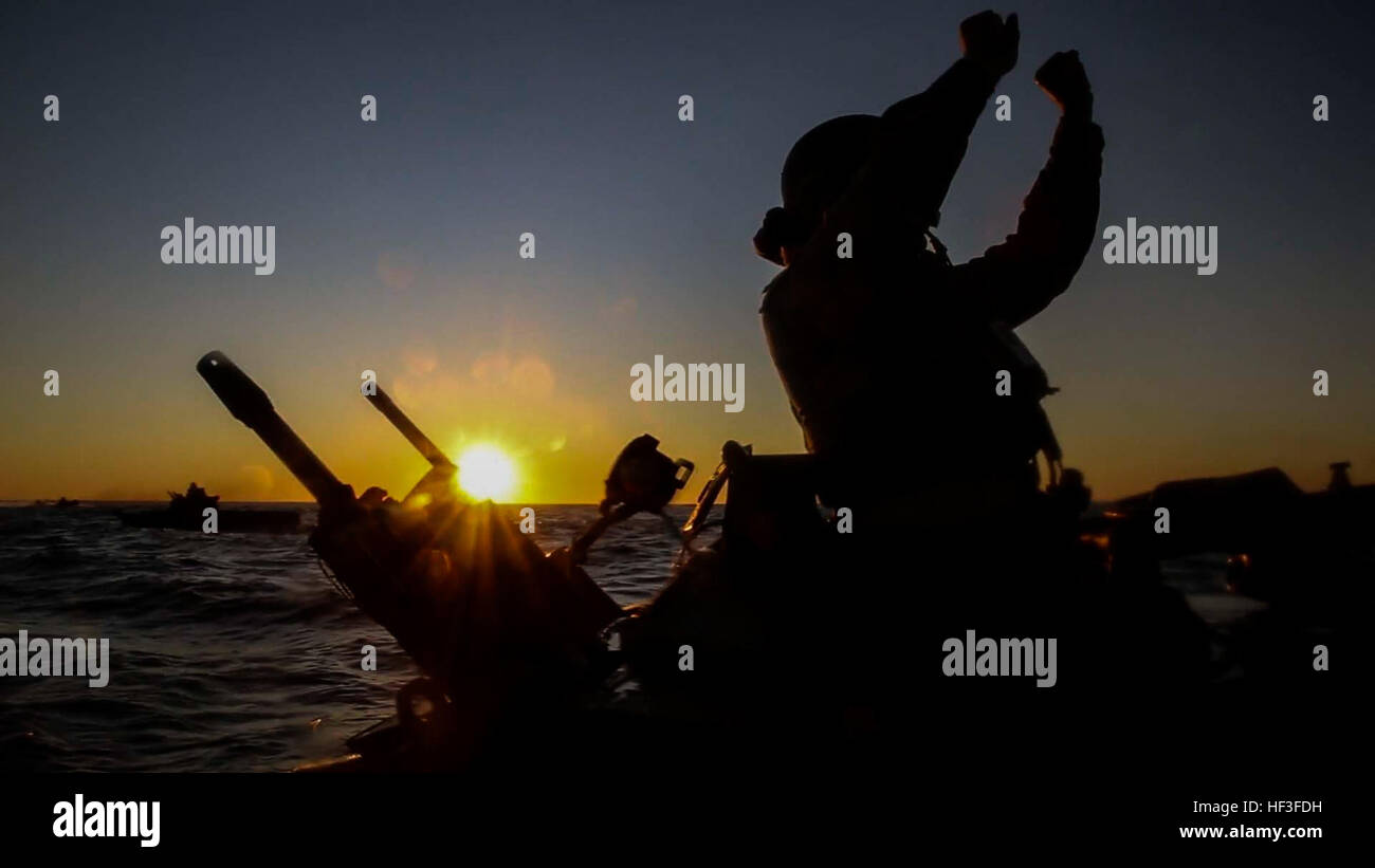 A U.S. Marine uses hand signals to communicate with other AAV-P7/A1 ...
