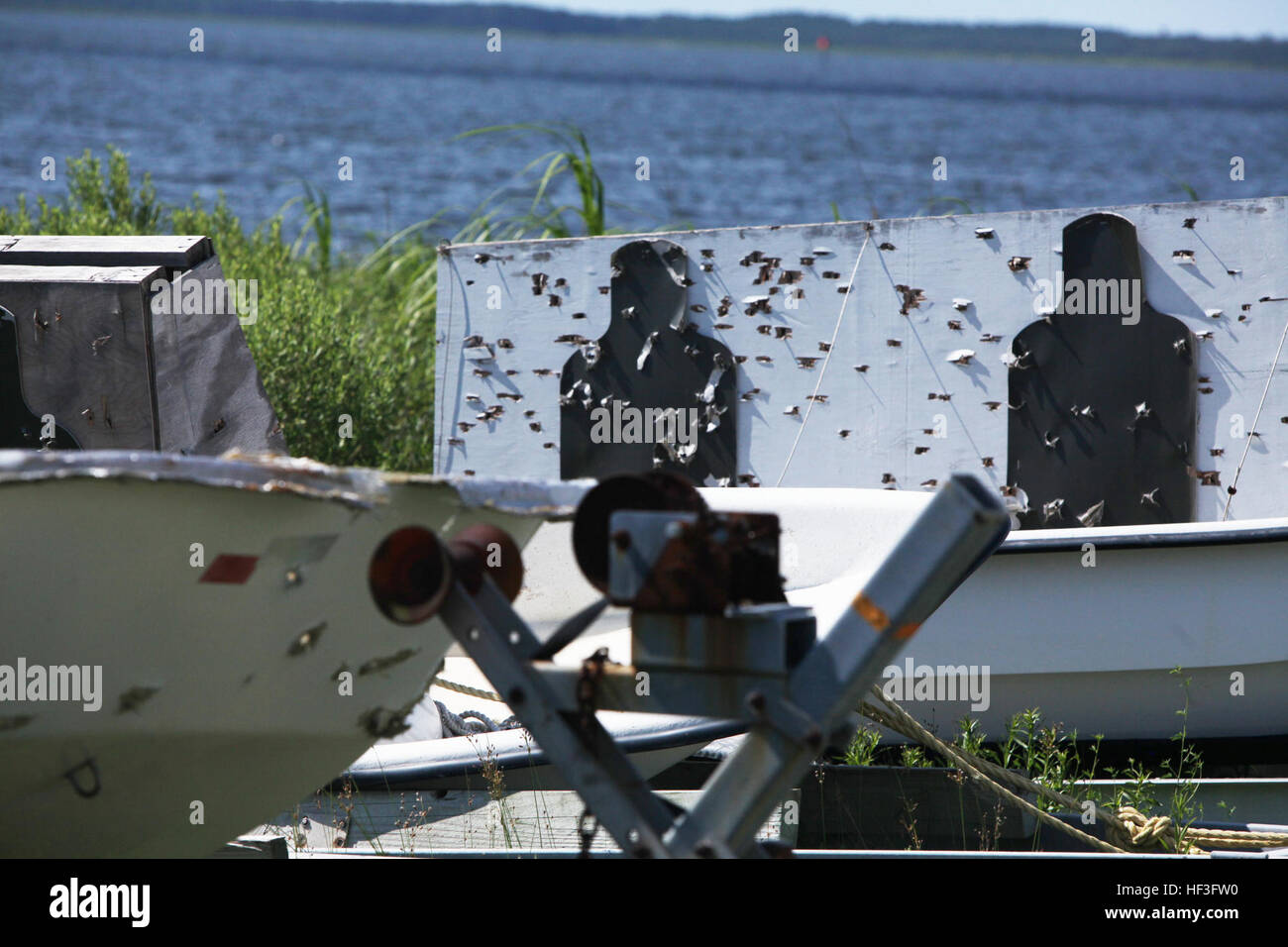 The aftermath of live-fire practice is shown on seaborne targets during target replenishing of Bombing Target 11, Piney Island, N.C., July 7, 2015. The new targets were installed to make it possible for all branches of service to practice their live-fire skills on visible targets. The more than 10,000 acre island is covered by different types of targets including: Barge targets, surface-to-air missile representations, tactical vehicle replicas and laser targets, which allow the pilots to train in various scenarios. (U.S. Marine Corps photo by Lance Cpl. Jason R. Jimenez/Released) Piney Island  Stock Photo