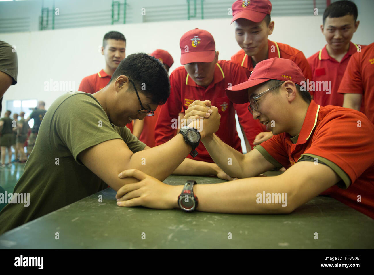 Lance Cpl. Paul J. Yi, chemical, biological, radiological and nuclear defense specialist with 4th Light Armored Reconnaissance Battalion, 4th Marine Division, arm wrestles Cpl. Min Wook Yoo, an infantryman with 5th Company, 2nd Battalion, 7th Regiment, 1st Marine Division, at warrior day during Peninsula Express 15 in Pohang, Republic of Korea, July 8, 2015. Both Yi and Woo served as interpreters for the exercise. Peninsula Express is this year’s eighth iteration of the Korean-Marine Exchange Program, a series of exercises between the U.S. and Republic of Korea Marine Corps designed to build i Stock Photo