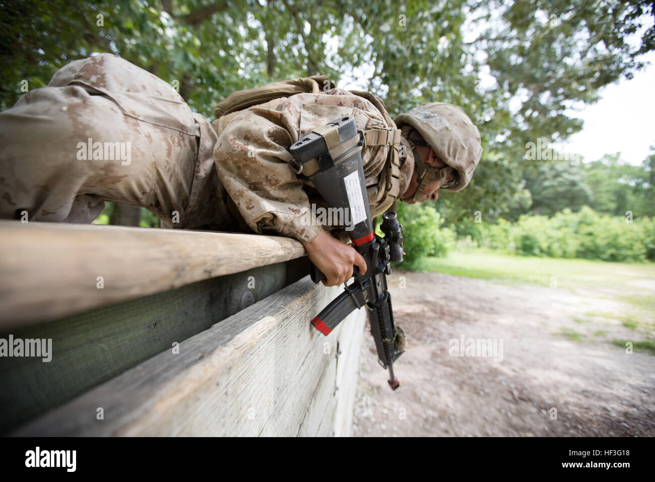 U.S. Marine Corps Pfc. Rafael J. Cubano, an entry-level Marine with Fox Company, Marine Combat Training Battalion (MCT), climbs over a wall while conduct a Military Operations on Urban Terrain drill during their Battle Skills Readiness Exercise (BSRE) on Camp Devil Dog, N.C., July 8, 2015. The BSRE is the culminating event consisting of a 24 hour evolution testing all the tactical skills learned during MCT. (U.S. Marine Corps photo by SOI-East Combat Camera, Cpl. Andrew Kuppers/Released) MCT Marines Conduct Final Field Exercise 150708-M-NT768-014 Stock Photo