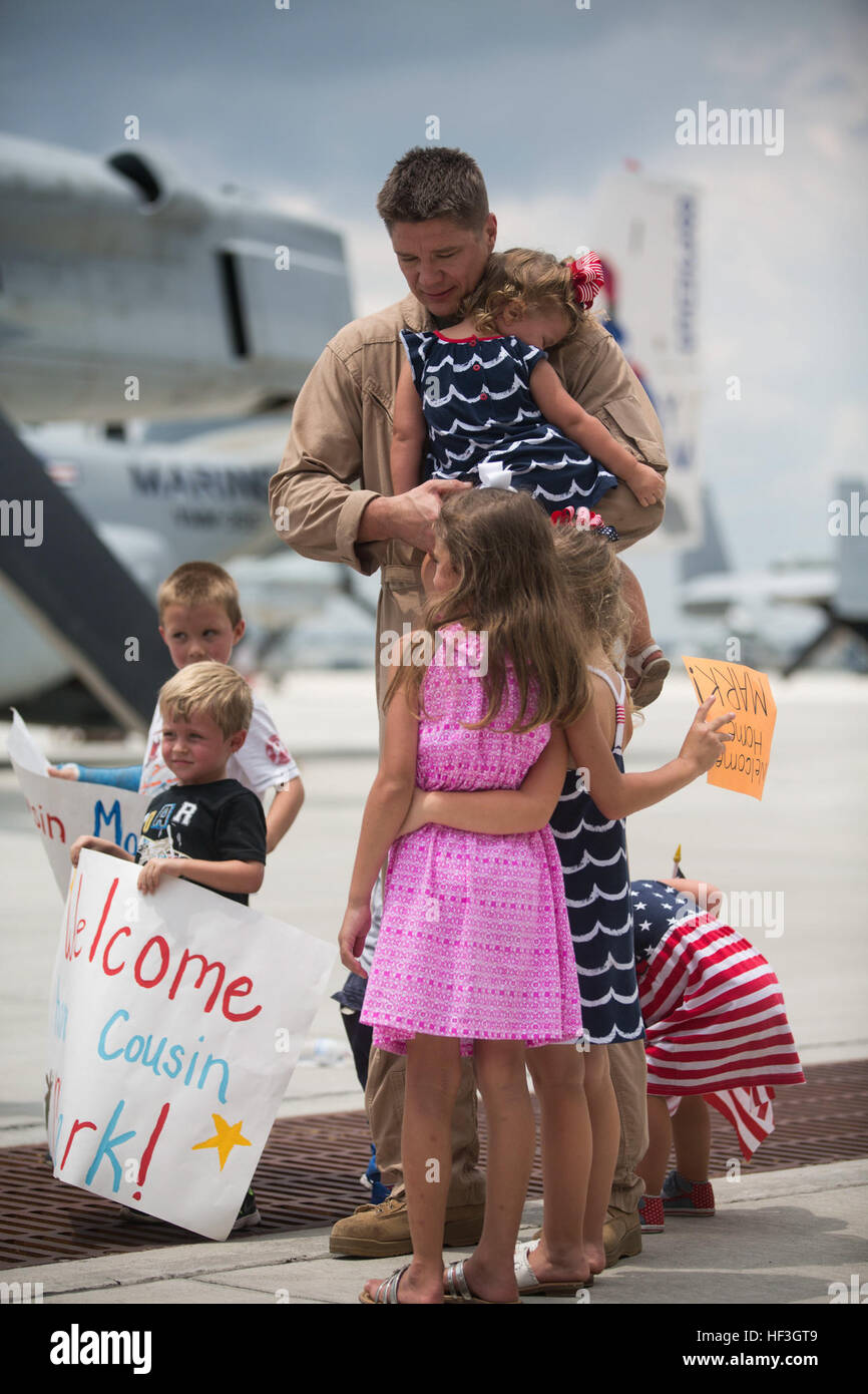 Major Mark Fowler, an MV-22B Osprey pilot with Marine Medium Tiltrotor Squadron 365 (Reinforced), 24th Marine Expeditionary Unit, reunites with his children during the Aviation Combat Element’s homecoming at Marine Corps Air Station New River, N.C. July 16, 2015. Marines and Sailors of the 24th MEU were embarked on the ships of the Iwo Jima Amphibious Ready Group and supported operations in the U.S. 5th and 6th Fleet area of operations. They also took part in numerous theater security cooperation exercises and training with allied partners such as Djibouti, Italy, Oman, Spain, France, Jordan,  Stock Photo