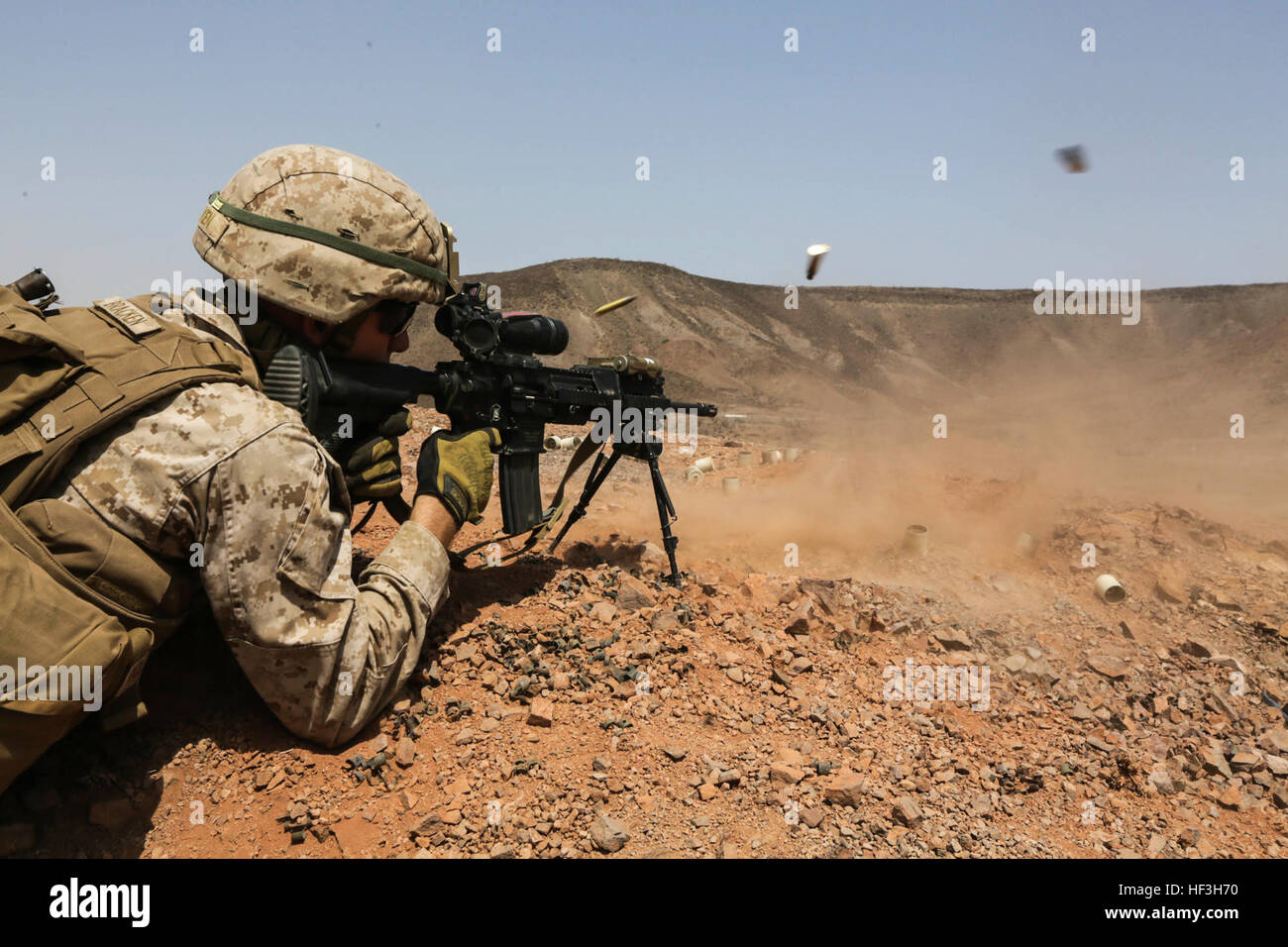 ARTA BEACH, Djibouti (July 22, 2015) A U.S. Marine with Battalion Landing Team 3rd Battalion, 1st Marine Regiment, 15th Marine Expeditionary Unit, fires an infantry automatic rifle during a squad-attack exercise.  The Marines of BLT 3/1 executed a series of attack and maneuver drills consisting of, machine gun, squad and night attacks.  Elements of the 15th Marine Expeditionary Unit are ashore in Djibouti for sustainment training to maintain and enhance the skills they developed during their pre-deployment training period.  The 15th MEU is currently deployed in support of maritime security ope Stock Photo