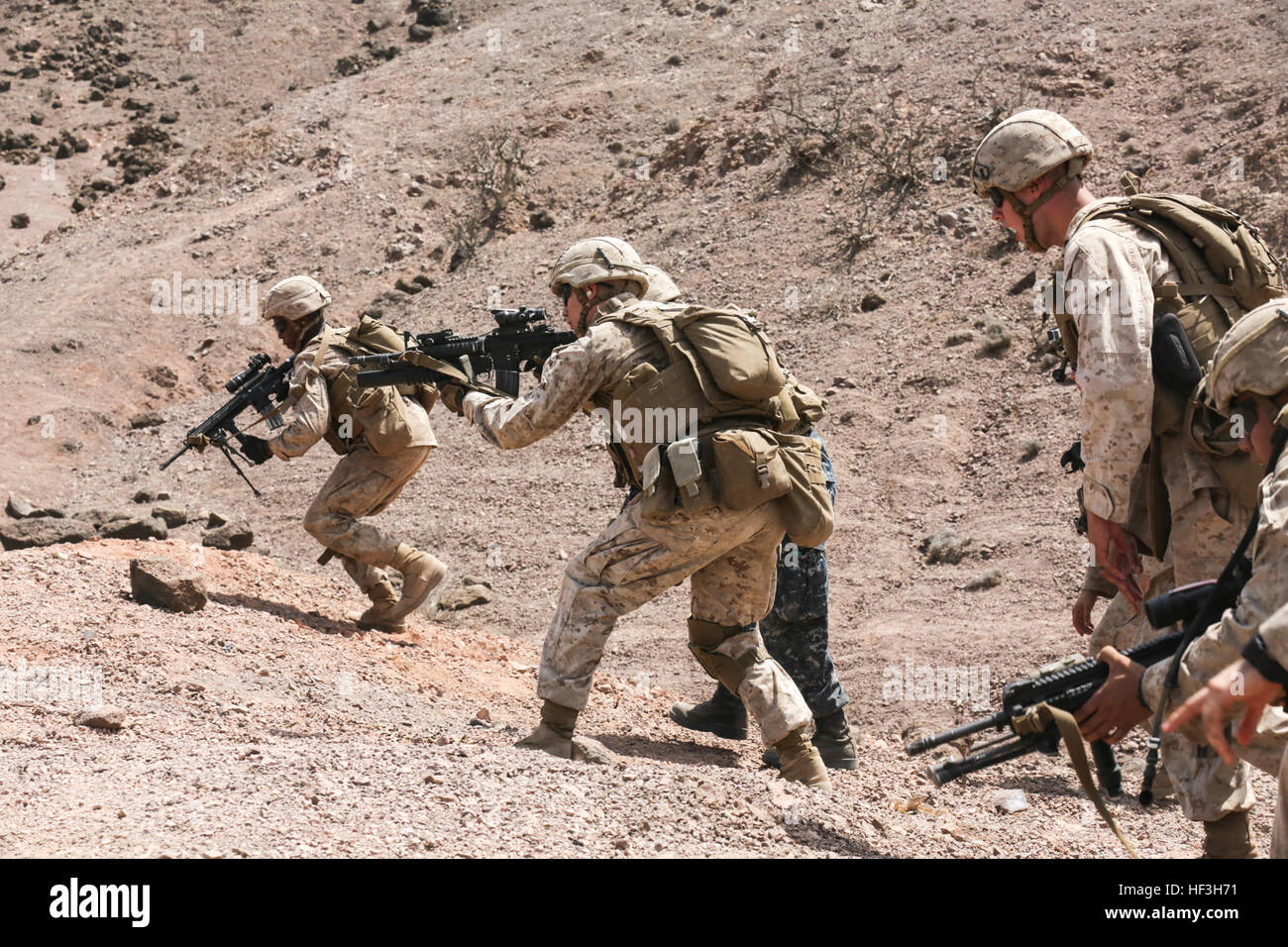 ARTA BEACH, Djibouti (July 22, 2015) U.S. Marines with Battalion Landing Team 3rd Battalion, 1st Marine Regiment, 15th Marine Expeditionary Unit, assault up to their fighting position during a squad-attack exercise.  The Marines of BLT 3/1 executed a series of attack and maneuver drills consisting of, machine gun, squad and night attacks.  Elements of the 15th Marine Expeditionary Unit are ashore in Djibouti for sustainment training to maintain and enhance the skills they developed during their pre-deployment training period.  The 15th MEU is currently deployed in support of maritime security  Stock Photo