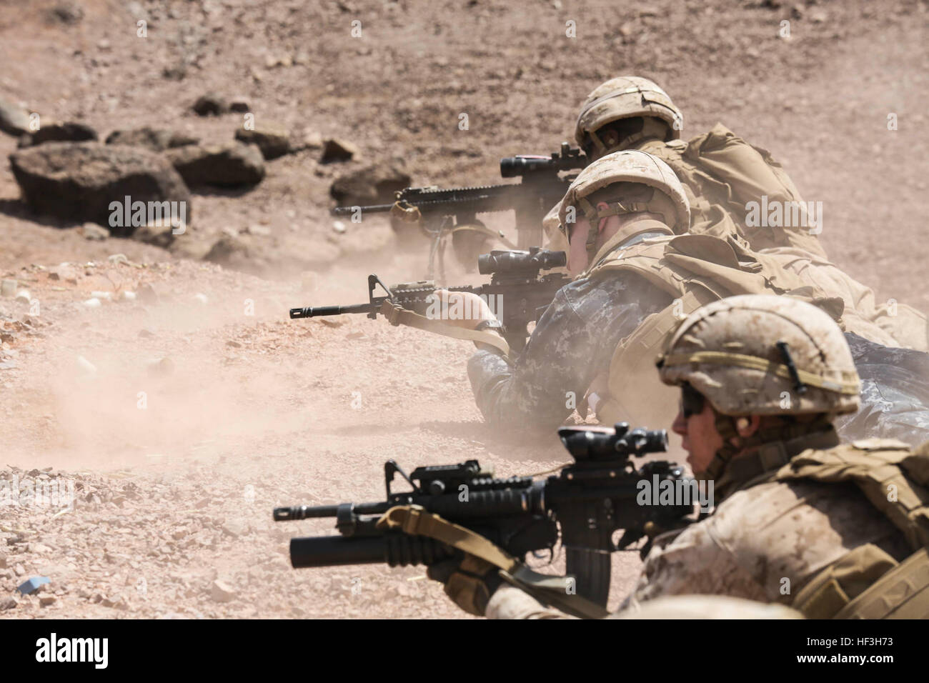 ARTA BEACH, Djibouti (July 22, 2015) U.S. Marines and U.S. Navy Sailors with Battalion Landing Team 3rd Battalion, 1st Marine Regiment, 15th Marine Expeditionary Unit and the USS Anchorage, fire their weapons during a squad-attack exercise.  The Marines of BLT 3/1 executed a series of attack and maneuver drills consisting of, machine gun, squad and night attacks.  Elements of the 15th Marine Expeditionary Unit are ashore in Djibouti for sustainment training to maintain and enhance the skills they developed during their pre-deployment training period.  The 15th MEU is currently deployed in supp Stock Photo