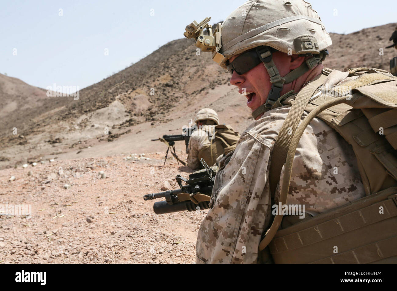 ARTA BEACH, Djibouti (July 22, 2015) A U.S. Marine team leader with Battalion Landing Team 3rd Battalion, 1st Marine Regiment, 15th Marine Expeditionary Unit, yells commands to his squad during a squad-attack exercise.  The Marines of BLT 3/1 executed a series of attack and maneuver drills consisting of, machine gun, squad and night attacks.  Elements of the 15th Marine Expeditionary Unit are ashore in Djibouti for sustainment training to maintain and enhance the skills they developed during their pre-deployment training period.  The 15th MEU is currently deployed in support of maritime securi Stock Photo