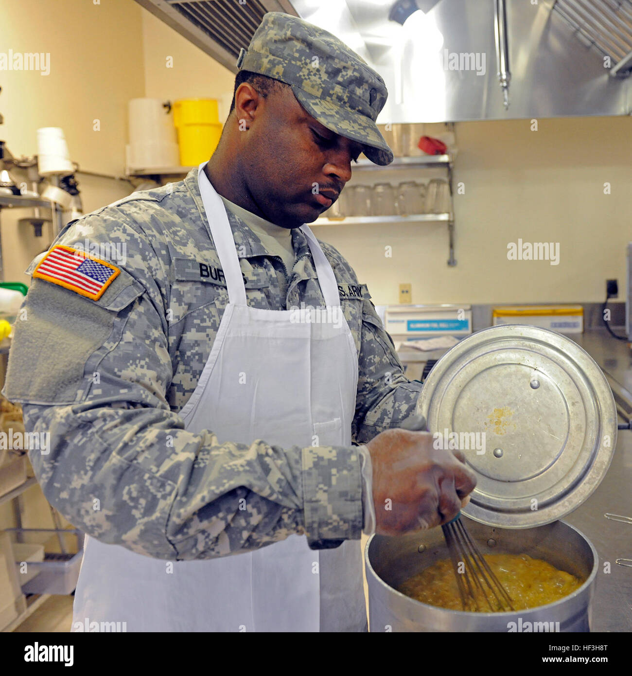 Spc. Jermaine Burns, of Indianola, Miss., assigned to the 1387th Quartermaster Company, Mississippi Army National Guard (MSARNG) stirs spicy brown rice pilaf during a food service workshop conducted by the Culinary Arts Institute at the Mississippi University for Women on July 23, 2015. The eighth-annual workshop provided MSARNG food service specialists with lecture and hands-on skill development designed not only to focus on the basics, but also to introduce advanced techniques relevant to Army food service programs. More than 75 Soldiers have been trained since the program’s inception in 200 Stock Photo