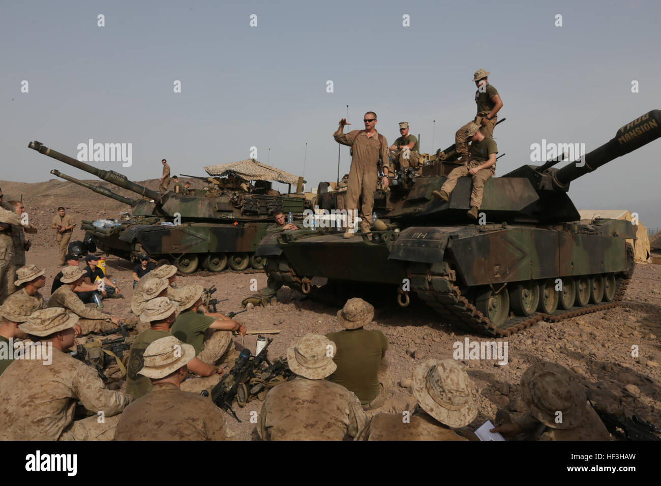 ARTA BEACH, Djibouti (July 24, 2015) U.S. Marine 1st Lt. Stephen Stone, center, teaches the Marines of Battalion Landing Team 3rd Battalion, 1st Marine Regiment, 15th Marine Expeditionary Unit, about the functions of an M1A1 Abrams tank.  Stone is a tank platoon commander with BLT 3/1, 15th MEU.  Elements of the 15th Marine Expeditionary Unit are ashore in Djibouti for sustainment training to maintain and enhance the skills they developed during their pre-deployment training period.  The 15th MEU is currently deployed in support of maritime security operations and theater security cooperation  Stock Photo