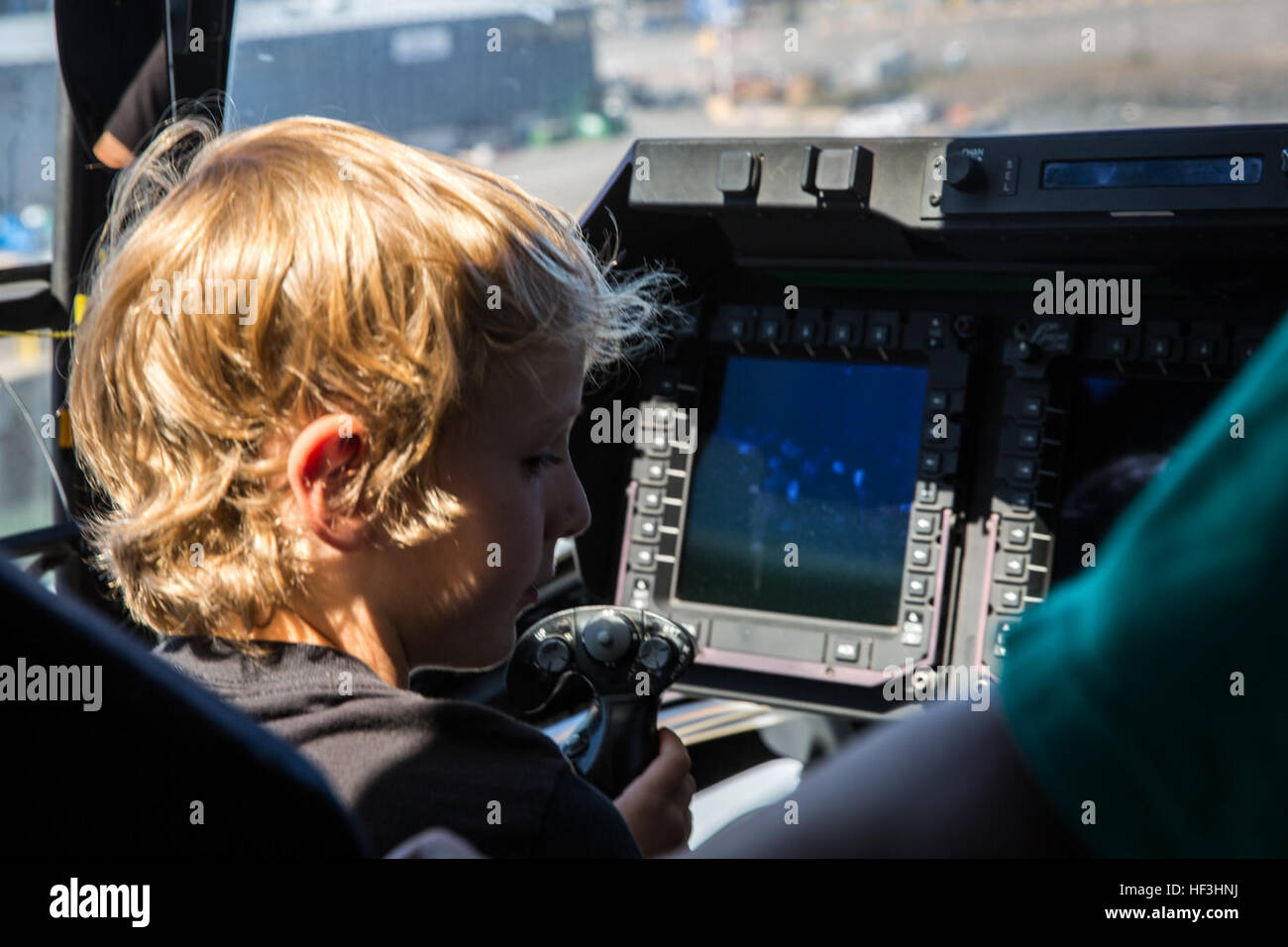 A boy sits in the cockpit of an MV-22B Osprey from Marine Medium Tiltrotor Squadron (VMM) 363 while touring the USS Boxer in Seattle, July 30. VMM-363 offered tours to people aboard the USS Boxer for Seattle Seafair Fleet Week. (U.S. Marine Corps photo by Sgt. Lillian Stephens/Released) Marines, Sailors welcome visitors aboard the USS Boxer 150730-M-QU349-037 Stock Photo