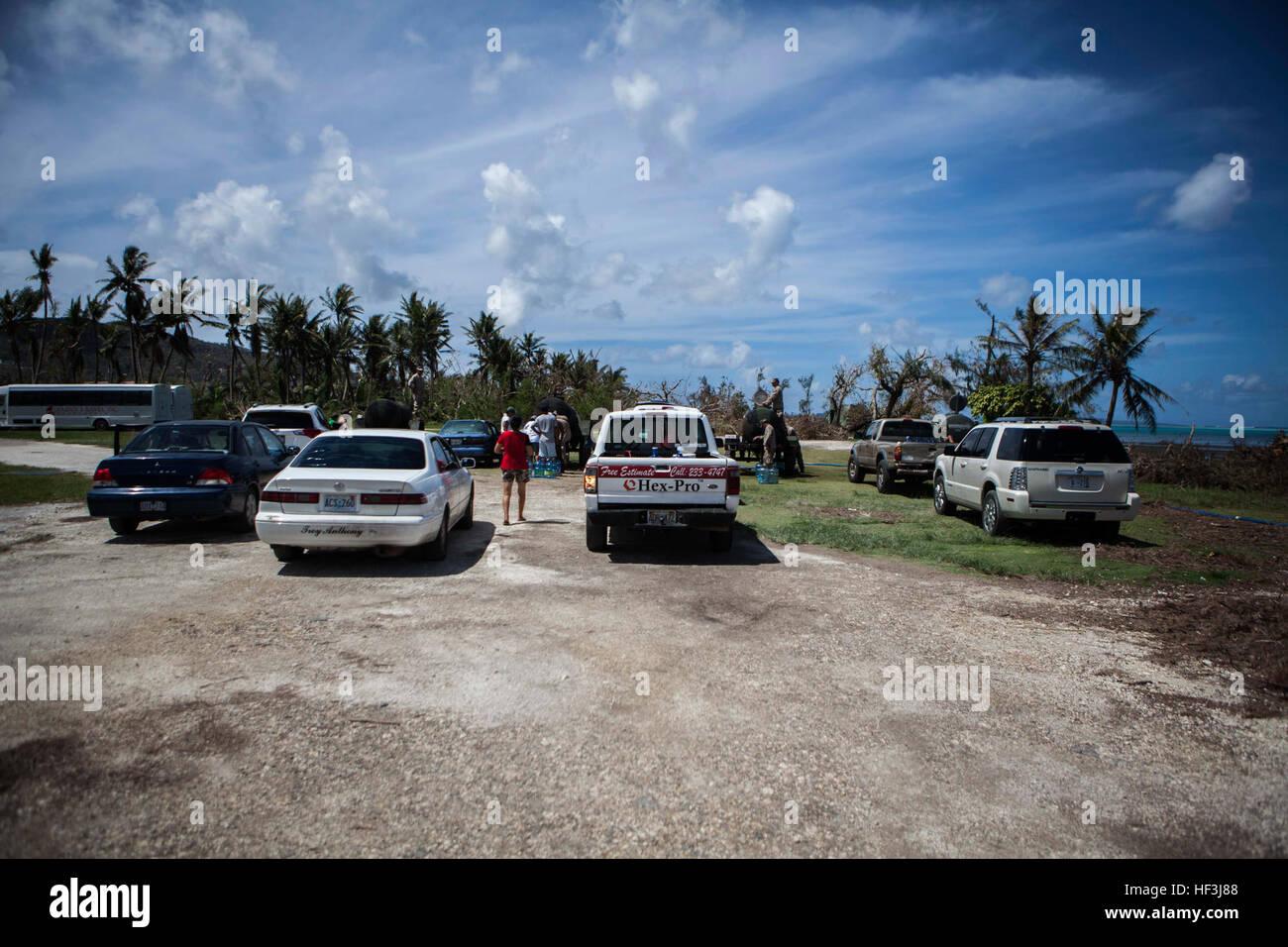 Vehicles wait in line as U.S. Marines with Combat Logistics Battalion 31, 31st Marine Expeditionary Unit, distribute water to local civilians during typhoon relief efforts in Saipan, Aug. 12, 2015. The 31st MEU and the ships of the Bonhomme Richard Amphibious Ready Group are assisting local and federal agencies with distributing emergency relief supplies to Saipan after the island was struck by Typhoon Soudelor Aug. 2-3. (U.S. Marine Corps photo by Gunnery Sgt. Ismael Pena/Released) Marines bring clean water to people of Saipan 150812-M-MX588-152 Stock Photo