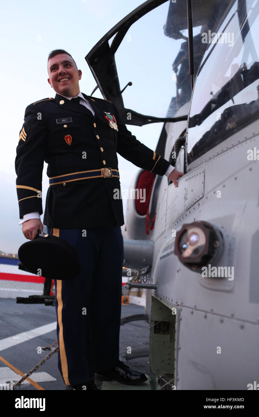 Army Sgt. Brandon B. Vilt, a former helicopter crew chief visiting with the wounded warriors, stands outside an AH-1W Super Cobra helicopter while visiting Special Purpose Marine Air Ground Task Force 26 Marines and USS New York sailors on a tour Nov. 5. SPMAGTF-26 was formed by North Carolina Marines from several units to support the commissioning of USS New York Nov. 7. (Official USMC photo by Lance Cpl. Brian M. Woodruff) USS New York Commissioning DVIDS221534 Stock Photo