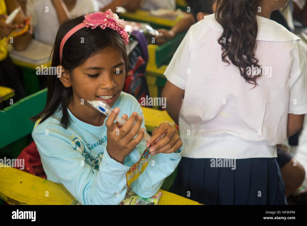 A student from Palawan, Philippines looks at her new toothbrush that ...