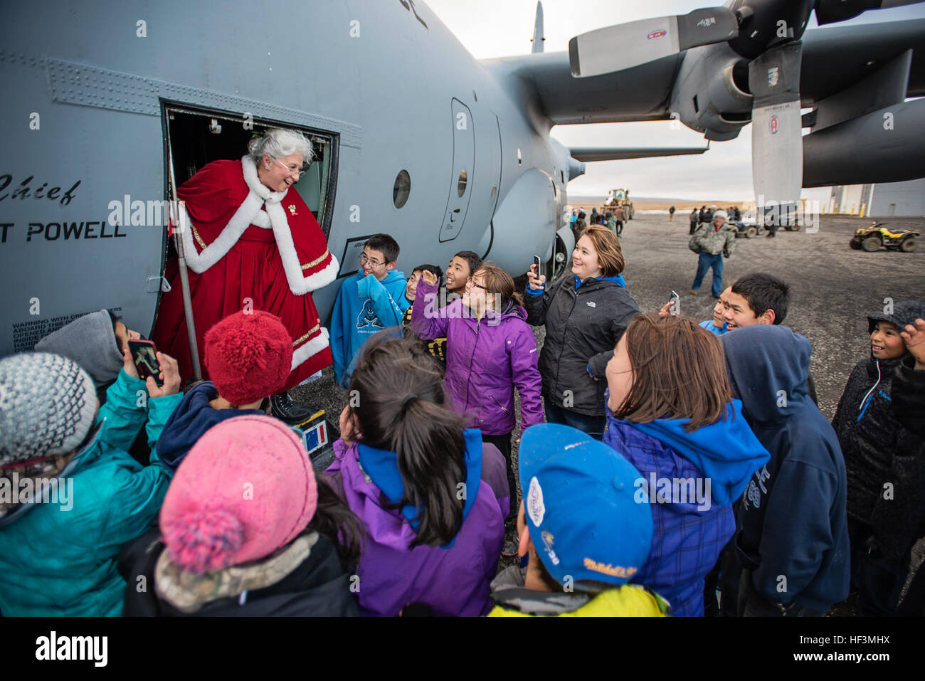 Children in Savoonga, Alaska, greet Mrs. Claus as she emerges from a C