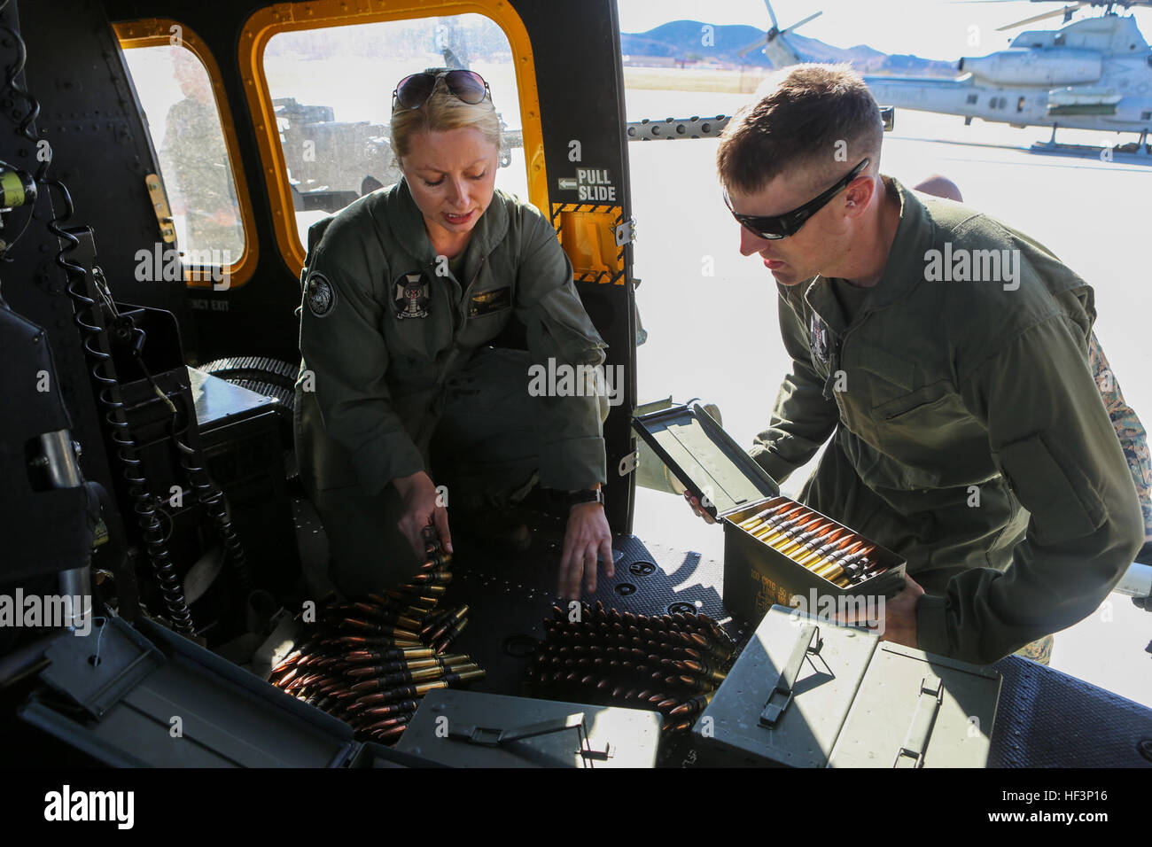 Sgt. Elizabeth M. Azcuenaga explains to 1st. Lt. James E. Shelton how to properly feed GAU-21/A .50 Caliber Machine Gun ammunition in order to reduce double feeds and jams in preparation for a Joint Terminal Attack Control training scenario Dec. 15, at Marine Corps Base Camp Pendleton, Calif. Azcuenaga, a Donnelly, Idaho, native, is a weapons and tactics instructor with Marine Light Attack Helicopter Squadron 169, Marine Aircraft Group 39, 3rd Marine Aircraft Wing. Shelton, a San Luis Obispo, California, native, is an aerial observer with HMLA-169, MAG 39, 3rd MAW. (Marine Corps photo by Cpl.  Stock Photo