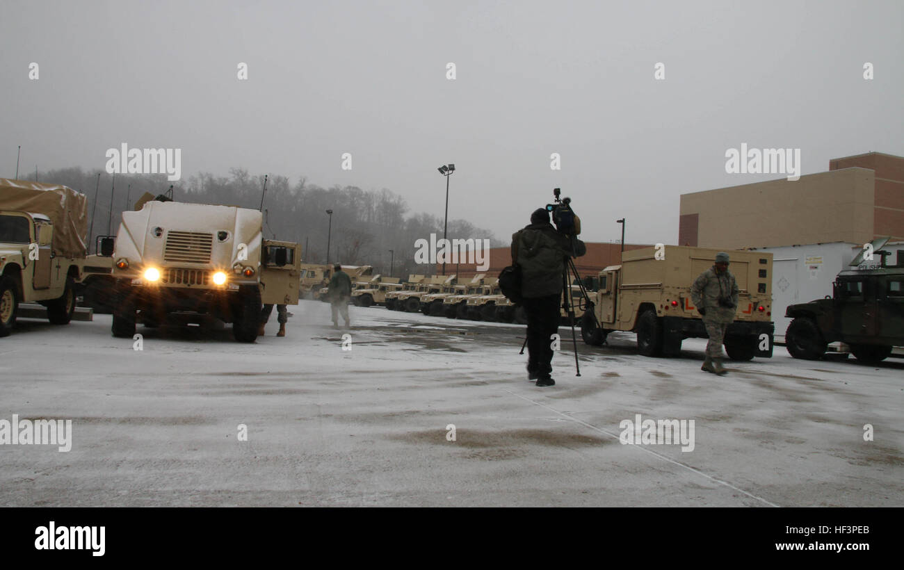 A reporter braves the cold to capture D.C. National Guard Soldiers and Airmen Tactical vehicles as they prepare to roll out into the District to support Metropolitan Police Department (MPD), Fire and Emergency Service Medical Department (FEMS) during Winter Storm Jonas, Joint Base Anacostia-Bolling, D.C., Jan. 22. District of Columbia National Guard Soldiers and Airmen answer the call to provide transportation support during freezing temperatures and heavy snowfall Jan. 22-25. DC Guard responds to winter's awakening; Winter Storm Jonas 160122-Z-XZ018-001 Stock Photo