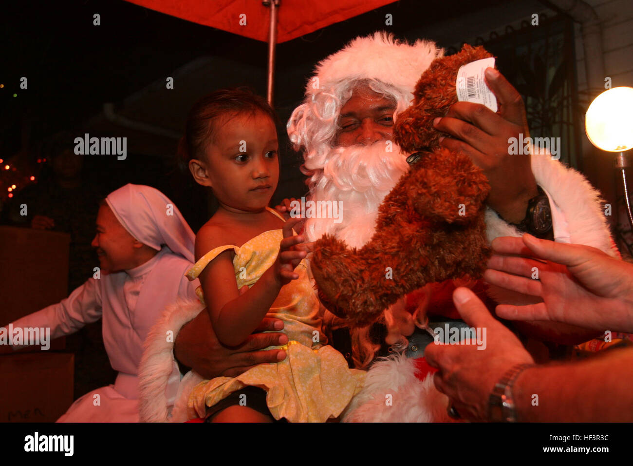 U.S. Marine Master Gunnery Sgt. Joseph Haggins, dressed as Santa Claus, present gifts to Filipino children during Operation Goodwill at Our Lady of Peace, Para'e, Republic of the Philippines, Dec. 15. Operation Goodwill is a chance for U.S. Marines and their families stationed in Okinawa, Japan, to help spread holiday spirit during the holiday season. Operation Goodwill gives hope to children, families in the Philippines DVIDS232177 Stock Photo