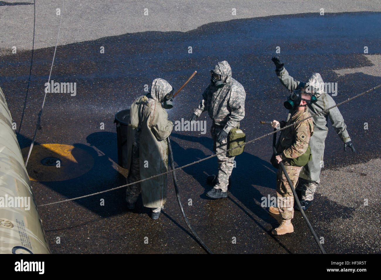 Army Reserve Chemical, Biological, Radiological and Nuclear specialists in the 366th Chemical Co., based out of Savannah, Ga., spray down a CH-47 Chinook helicopter belonging to Company B, 1st Battalion, 168th Aviation Regiment, 40th Combat Aviation Brigade, at Camp Arifjan, Kuwait, Feb. 9. CBRN procedures are covered by Camp Arifjan’s pre-accident plan, which covers a wide range of emergencies that could occur during operations. (Photo by Staff Sgt. Ian M. Kummer, 40th Combat Aviation Brigade Public Affairs) 40th CAB and 366th Chemical Co. train for CBRN attack 160209-Z-JK353-015 Stock Photo