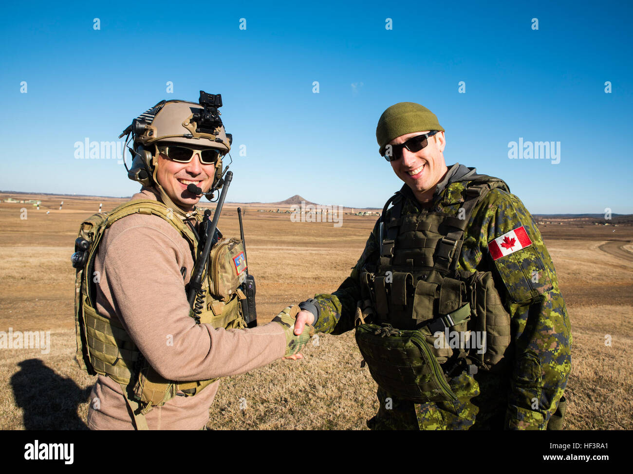 Tech. Sgt. Rob Ellis, 188th Wing joint terminal attack controller, shakes hands with Capt. James Neely, Y Battery 2nd Regiment Royal Canadian Horse Artillery JTAC, Feb. 10, 2016, during training held at Razorback Range, Fort Chaffee Joint Maneuver Training Center, Fort Smith, Ark. Nelly and Ellis met in Gilla Bend, Ariz., and discussed the possibility of having the 2RCHA train at Razorback Range. Canadian JTACs are required to train abroad at least twice a year and chose to come to Razorback Range for one of those sessions. (U.S. Air National Guard photo by Senior Airman Cody Martin/Released)  Stock Photo